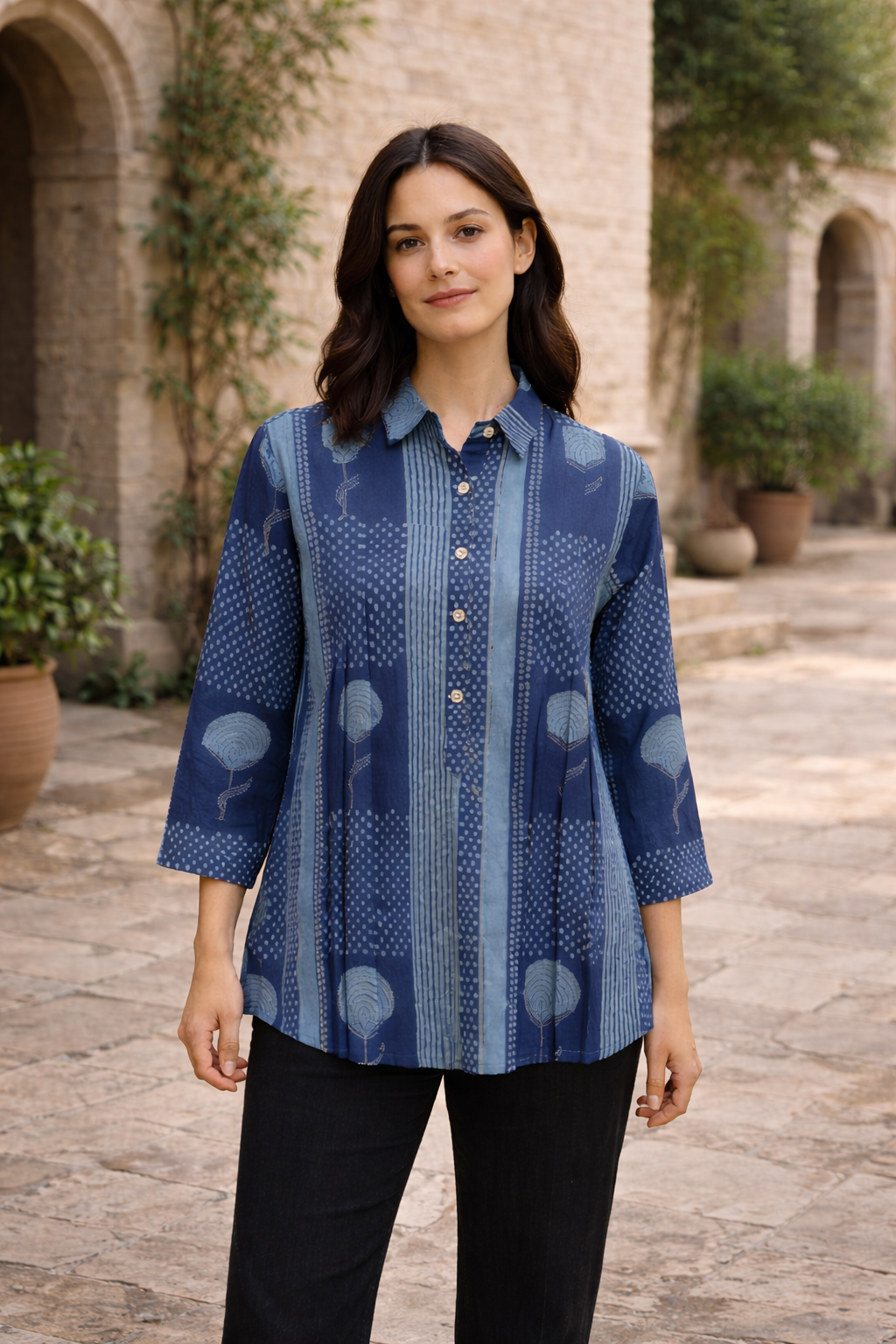 A model wearing a blue, hand-block-printed top with a floral pattern.