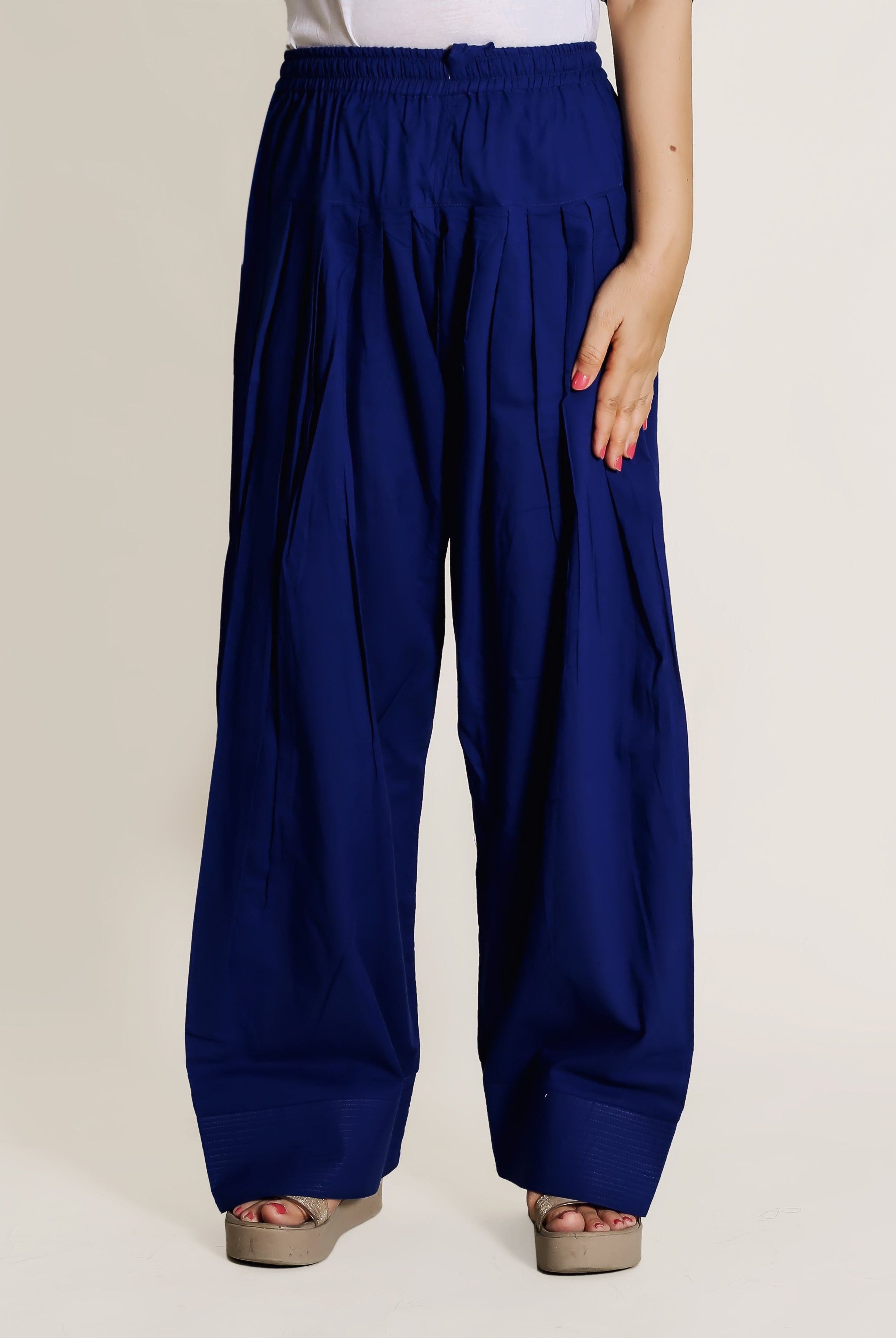 Front view of model wearing solid blue pleated wide-leg Farshi Salwar pants.