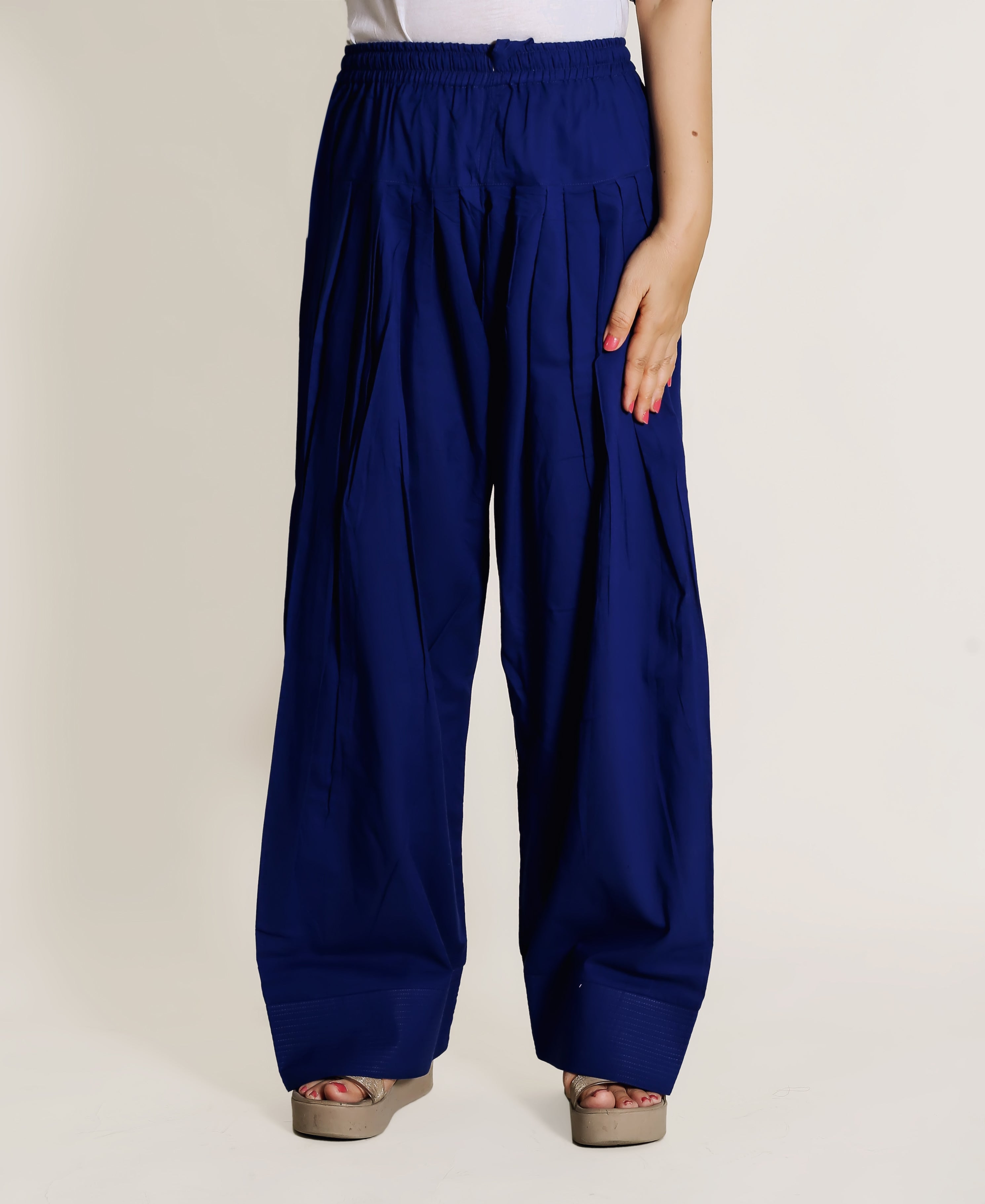Front view of model wearing solid blue pleated wide-leg Farshi Salwar pants.