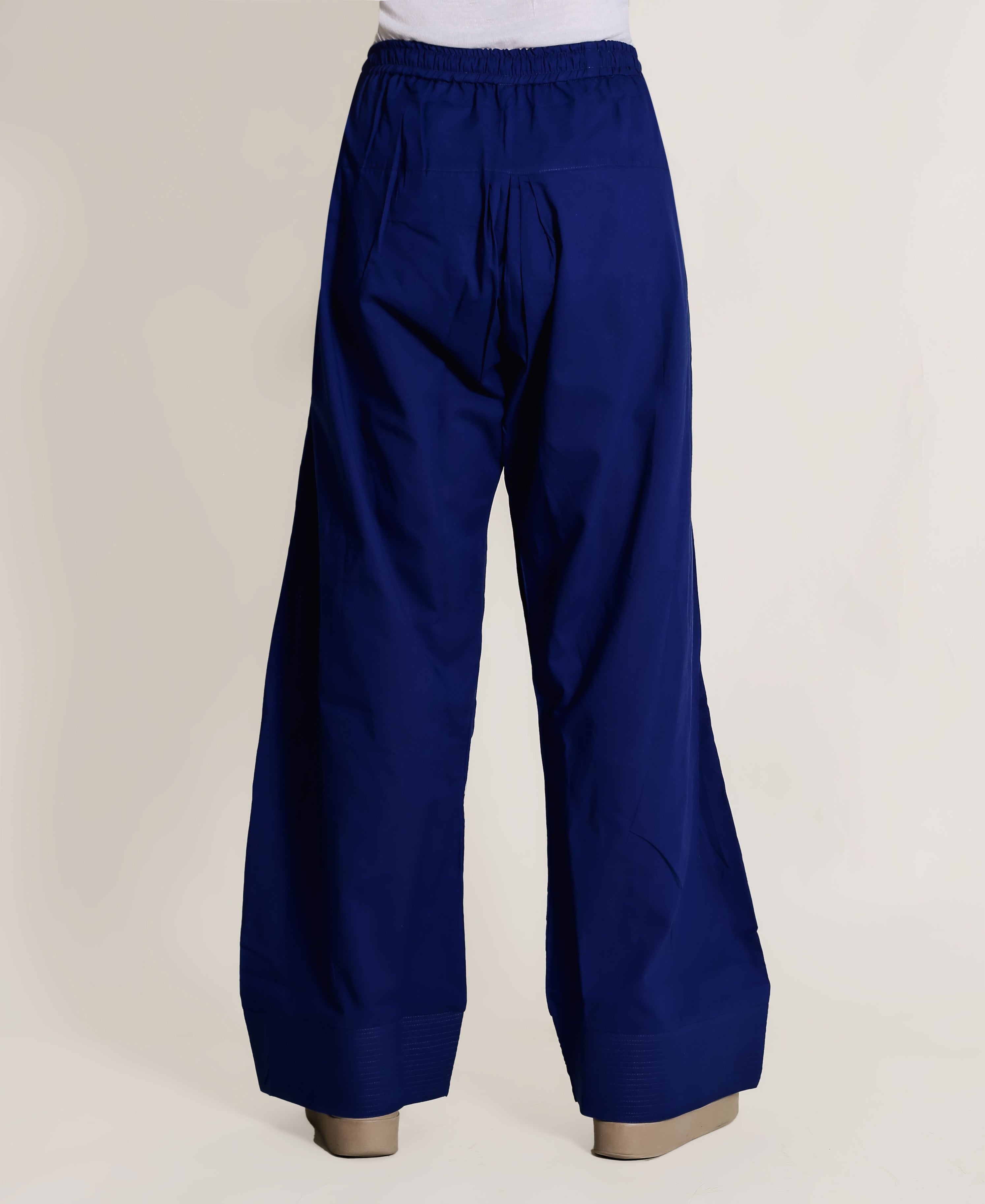 Royal blue wide-leg pants with elastic waistband and plain fabric, on a model from behind.