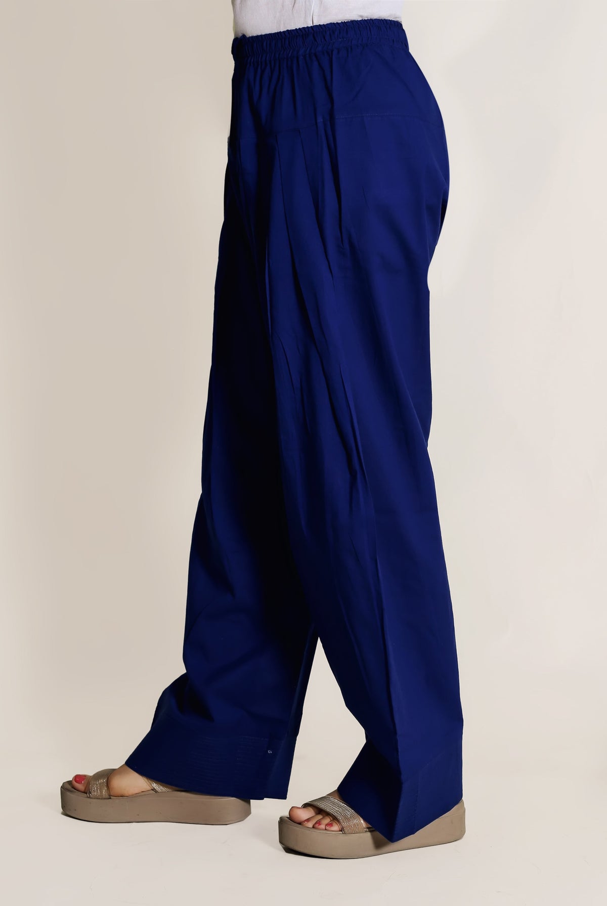 Side view of a person wearing solid royal blue wide-legged Farshi Salwar with an elasticated waist.