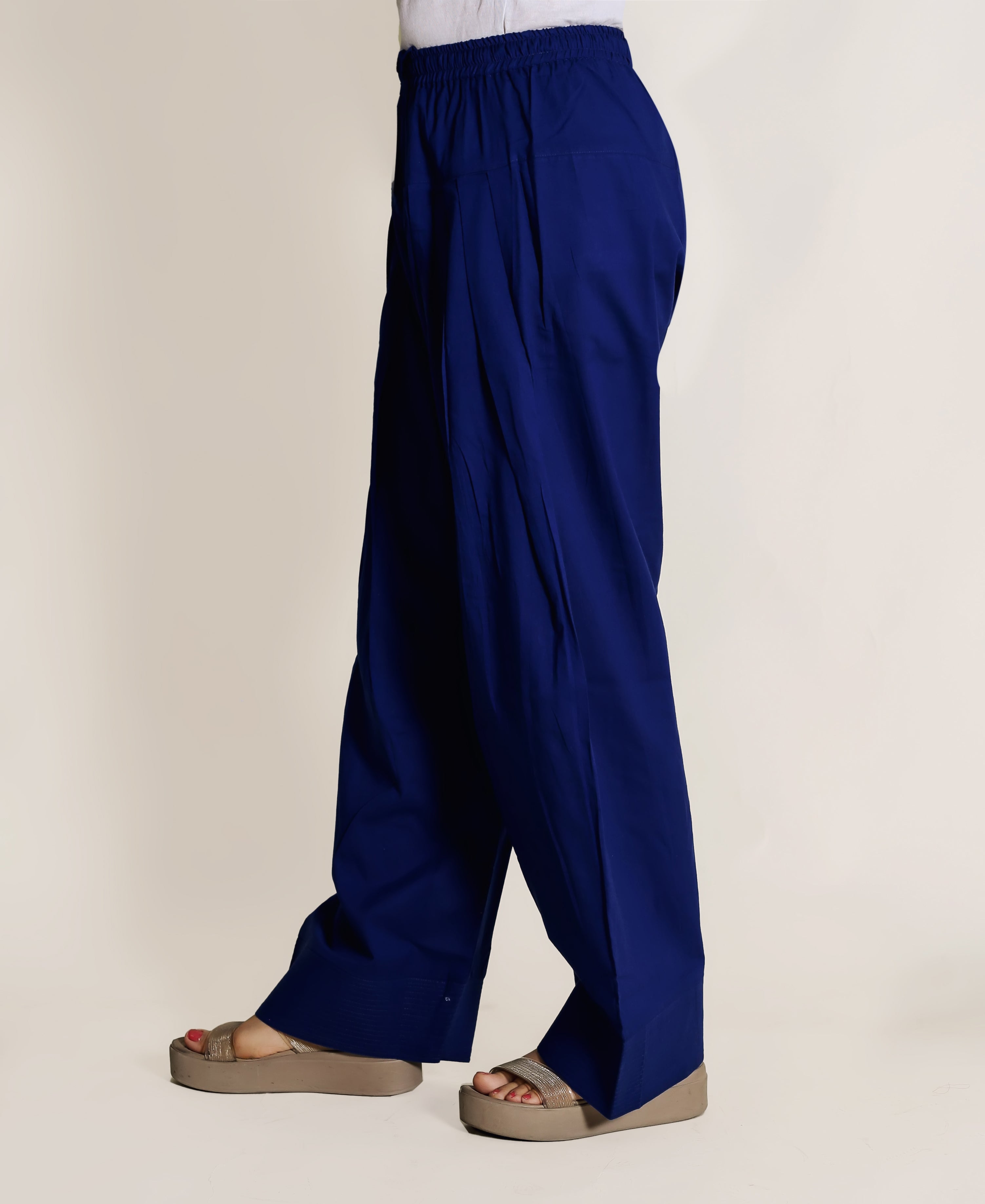 Side view of a person wearing solid royal blue wide-legged Farshi Salwar with an elasticated waist.