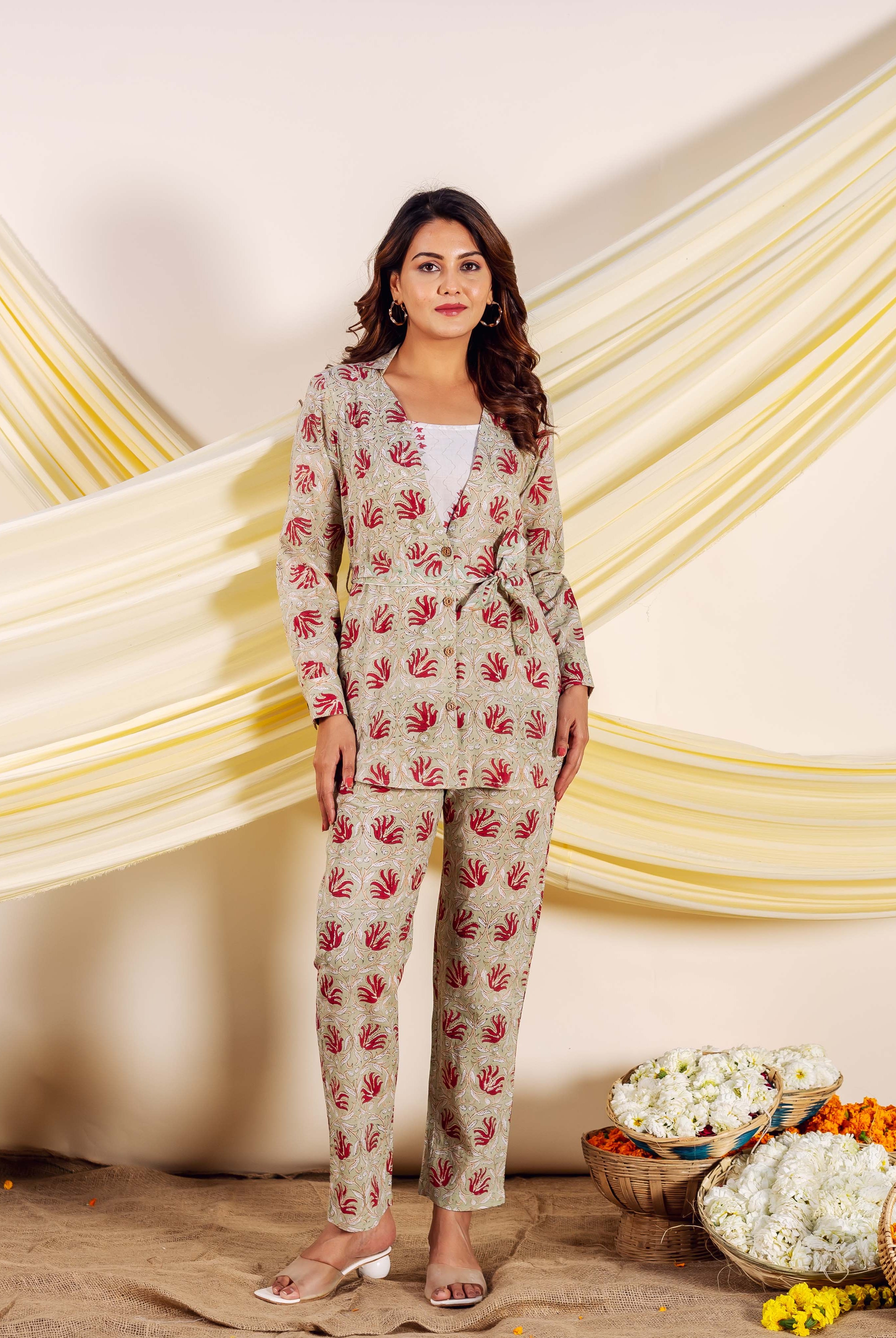 Full shot of model in a beige hand-block-printed co-ord set with red leaf motifs.