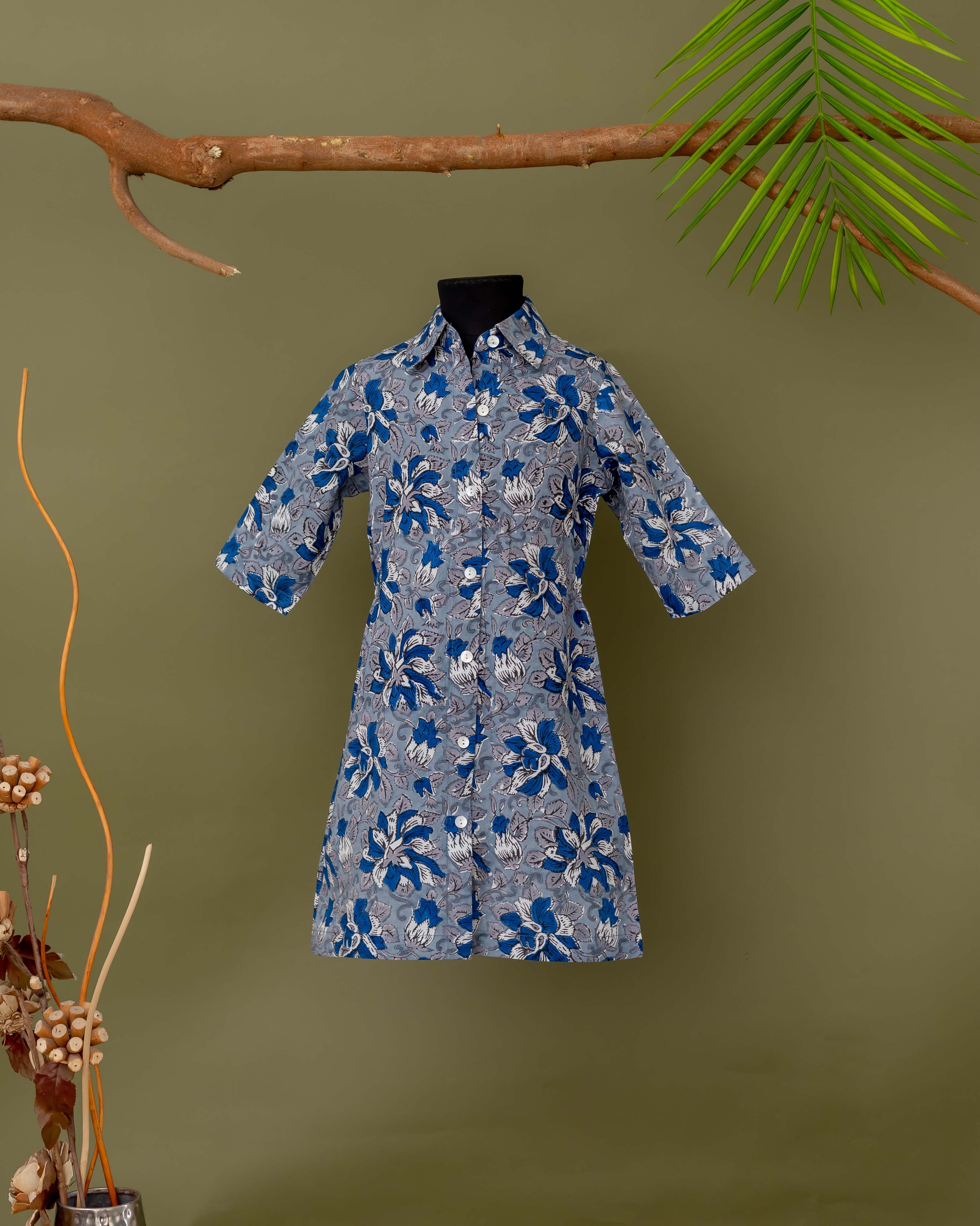 Flat lay of a blue and grey floral button-down dress with a hand-block print.