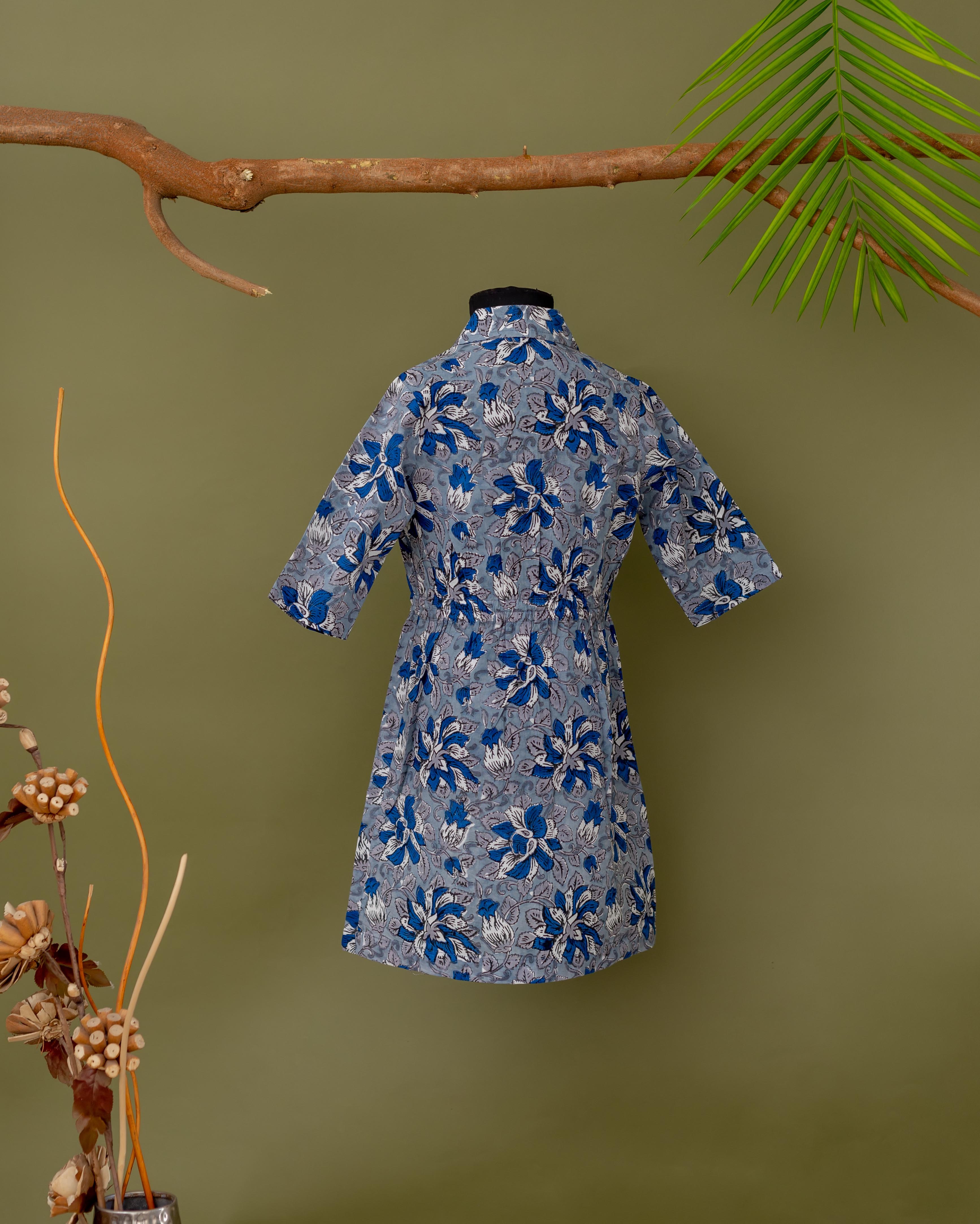 Back view of blue and grey floral print baby girl's collared dress with short sleeves.