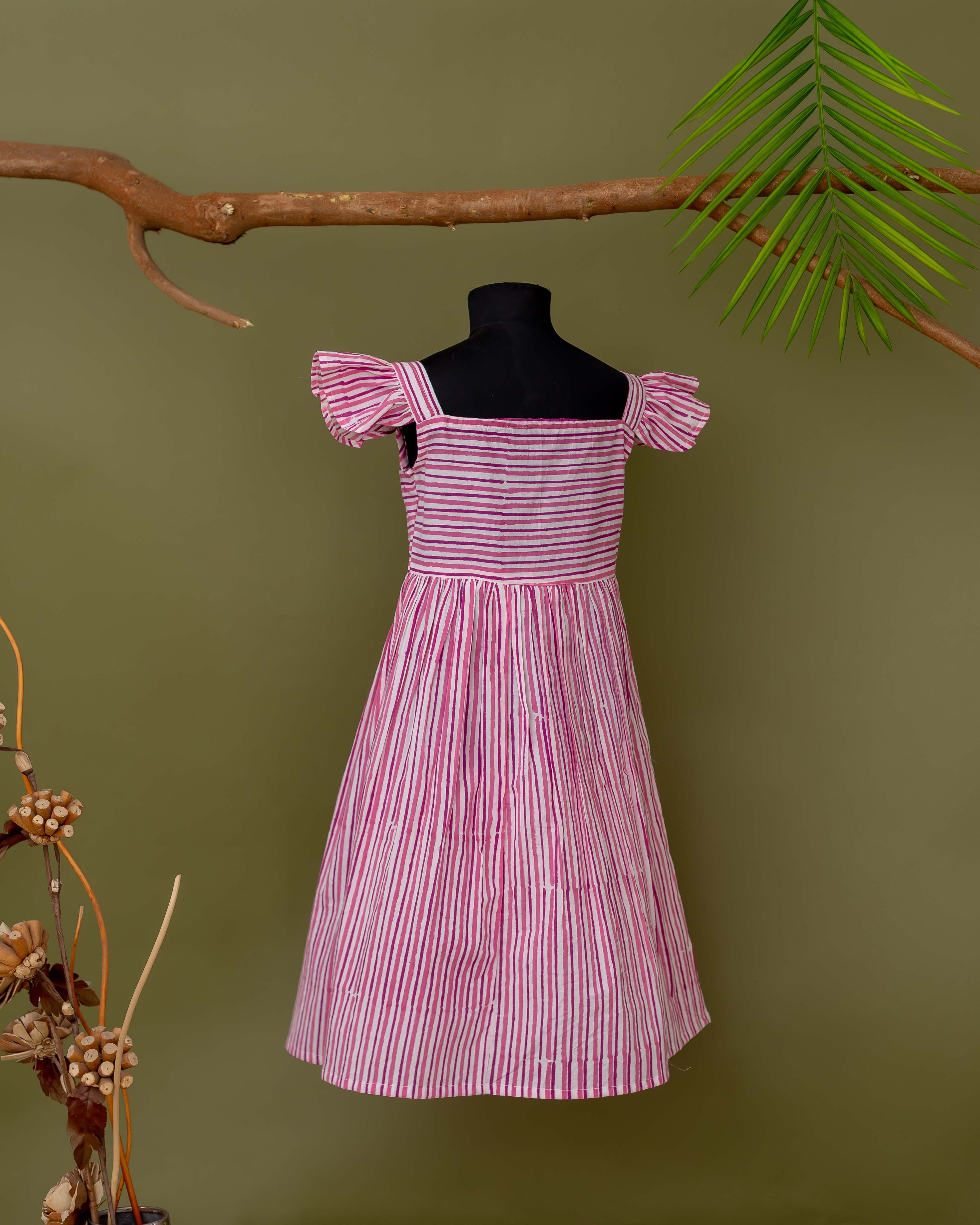 Pink and white hand block printed striped dress on mannequin, with square neck and ruffled sleeves.