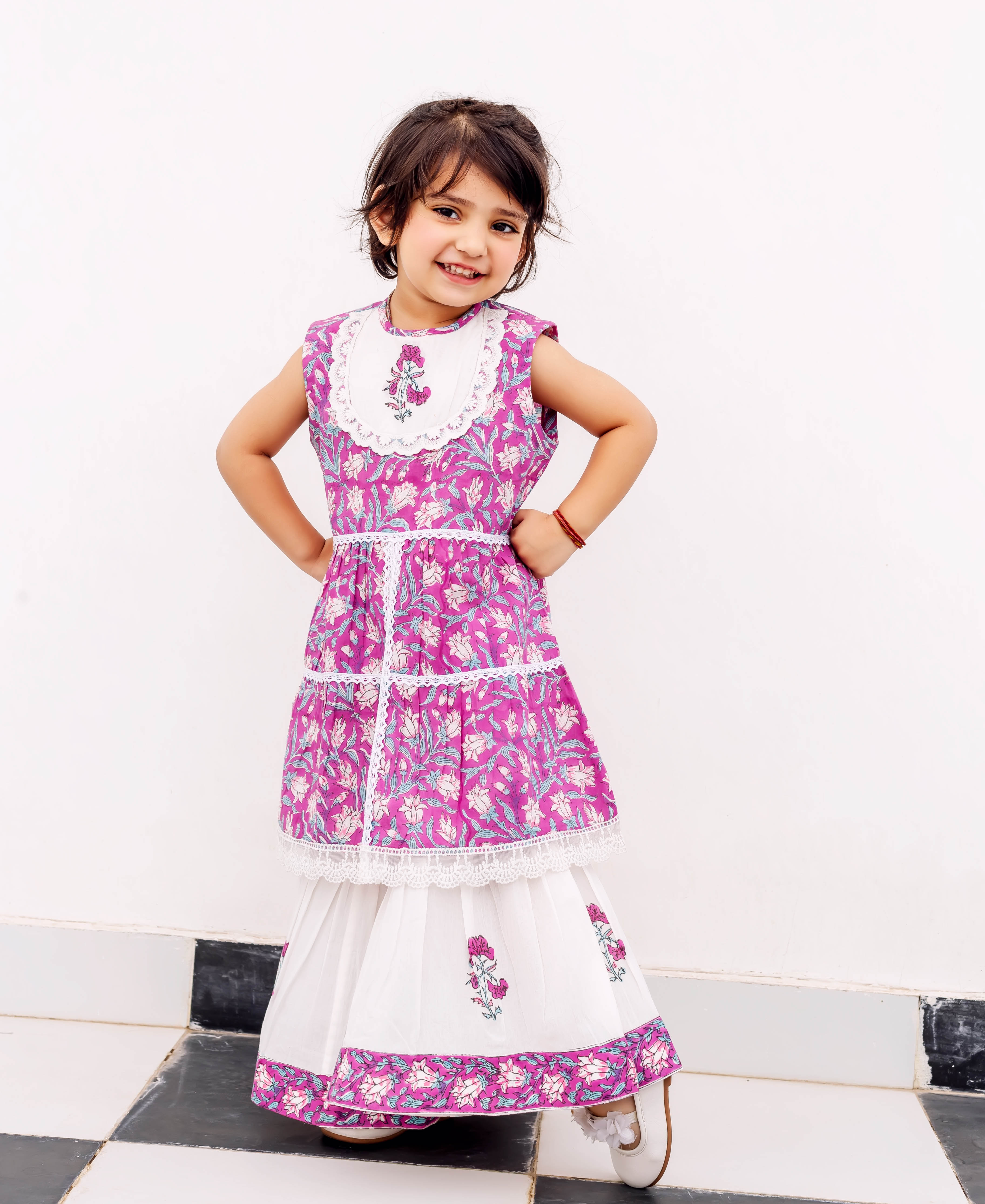 Young girl models a purple and white hand-block printed floral cotton kurta and sharara.