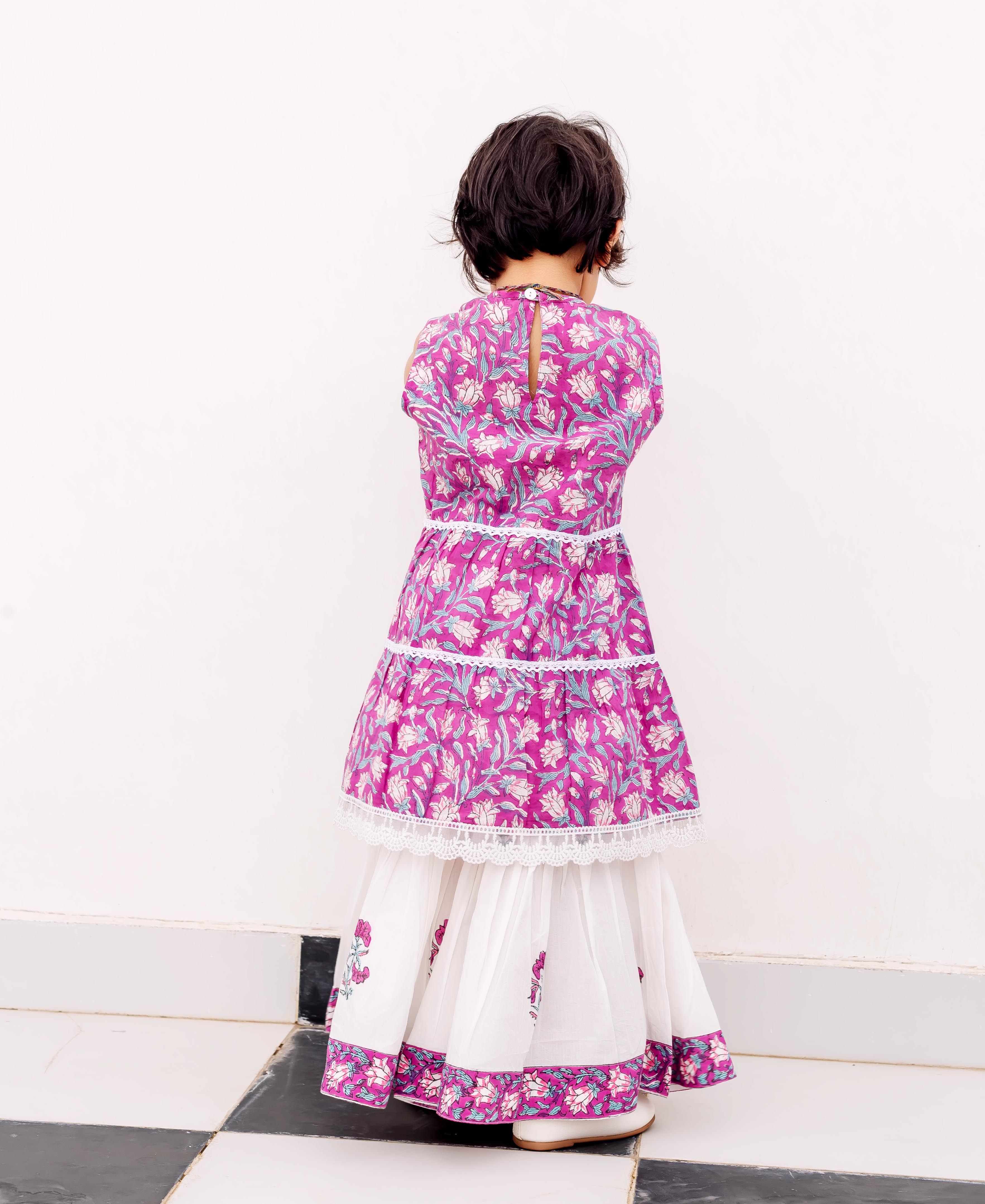 Back view of child in purple and white floral hand-block printed kurta and sharara.