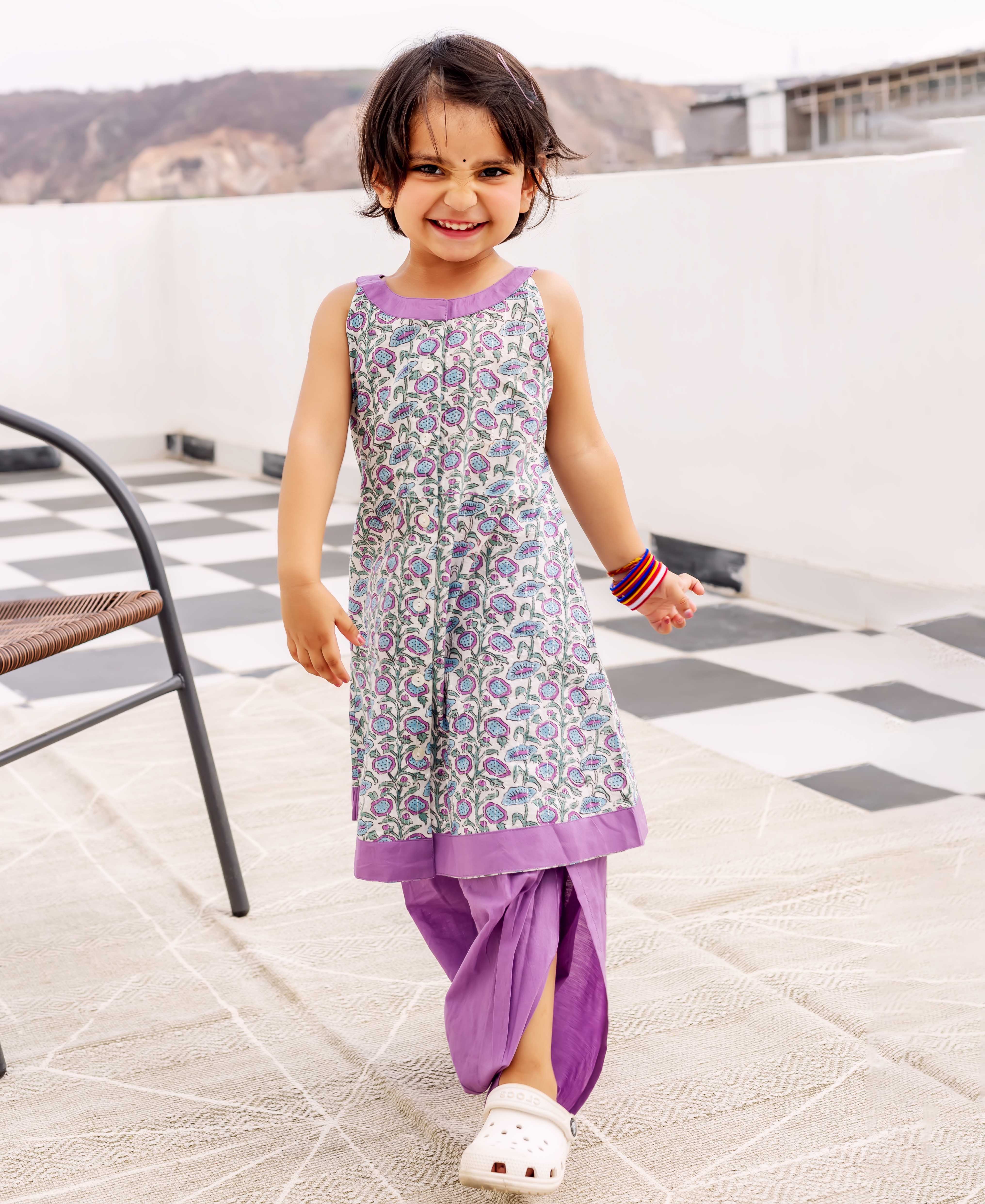 Young girl in purple and white hand block printed floral kurta and dhoti.
