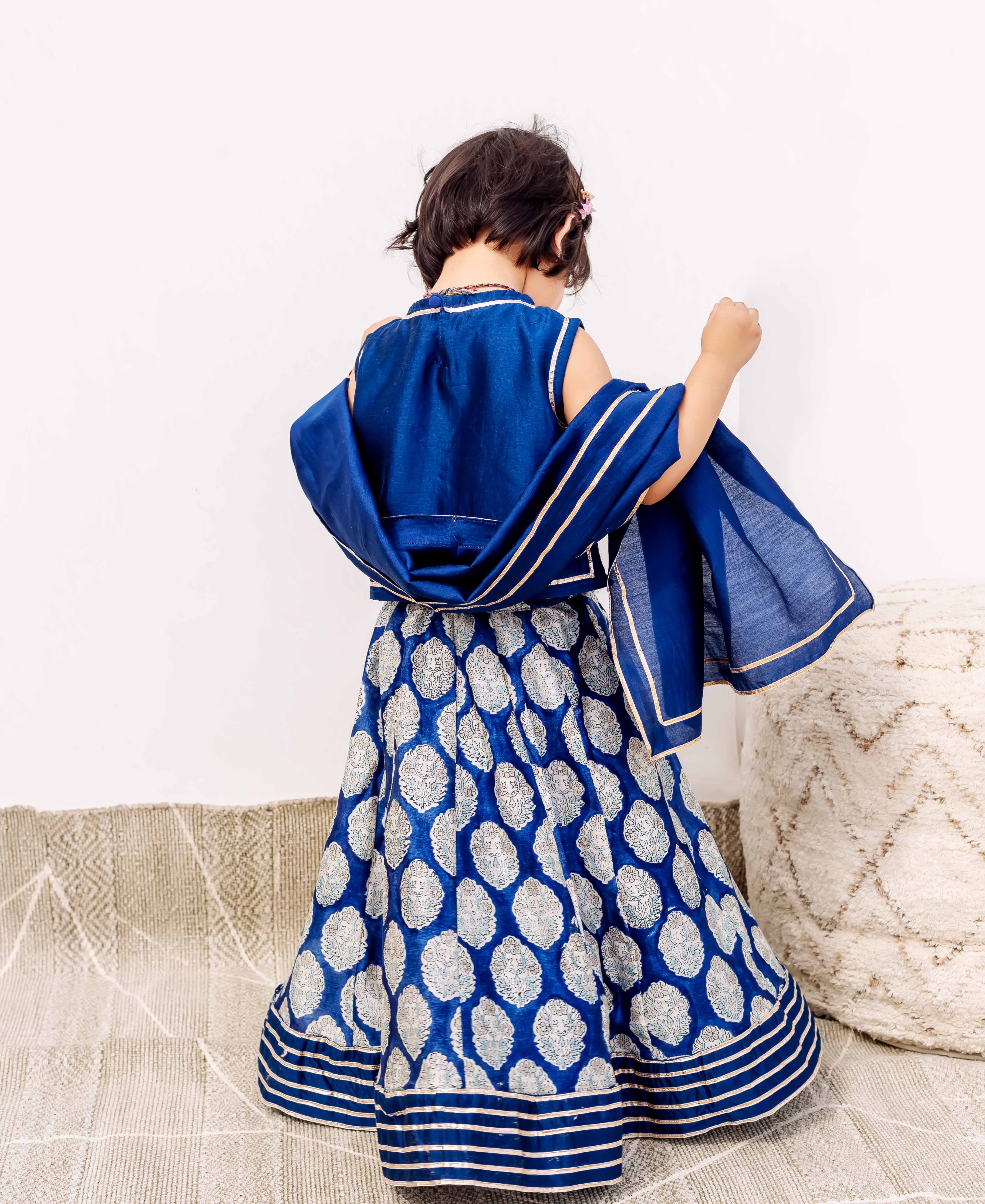 Child from back, royal blue silk lehenga with white block print and matching dupatta.