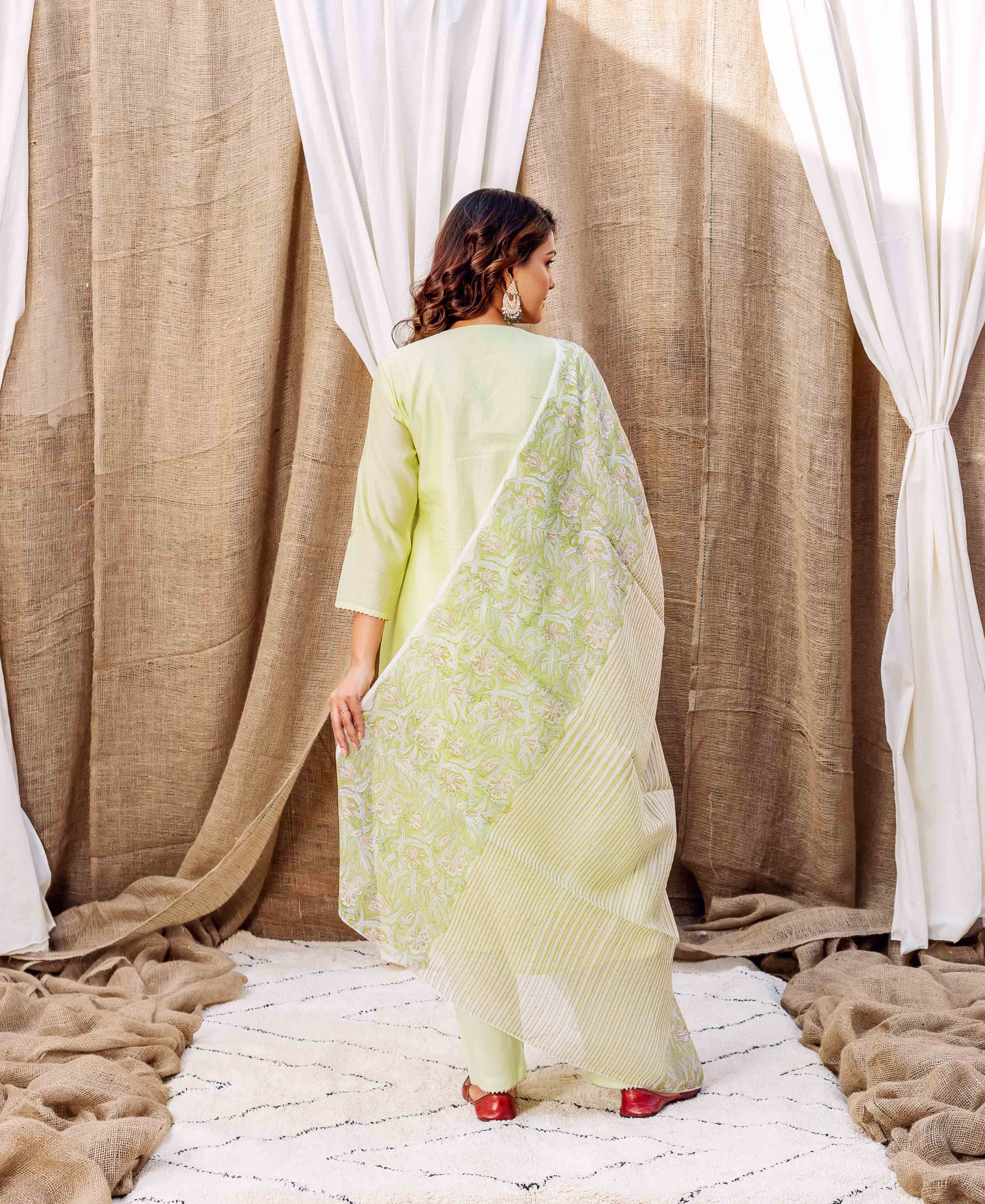 Model from back wearing a lime green kurta and floral hand-block-printed striped dupatta.