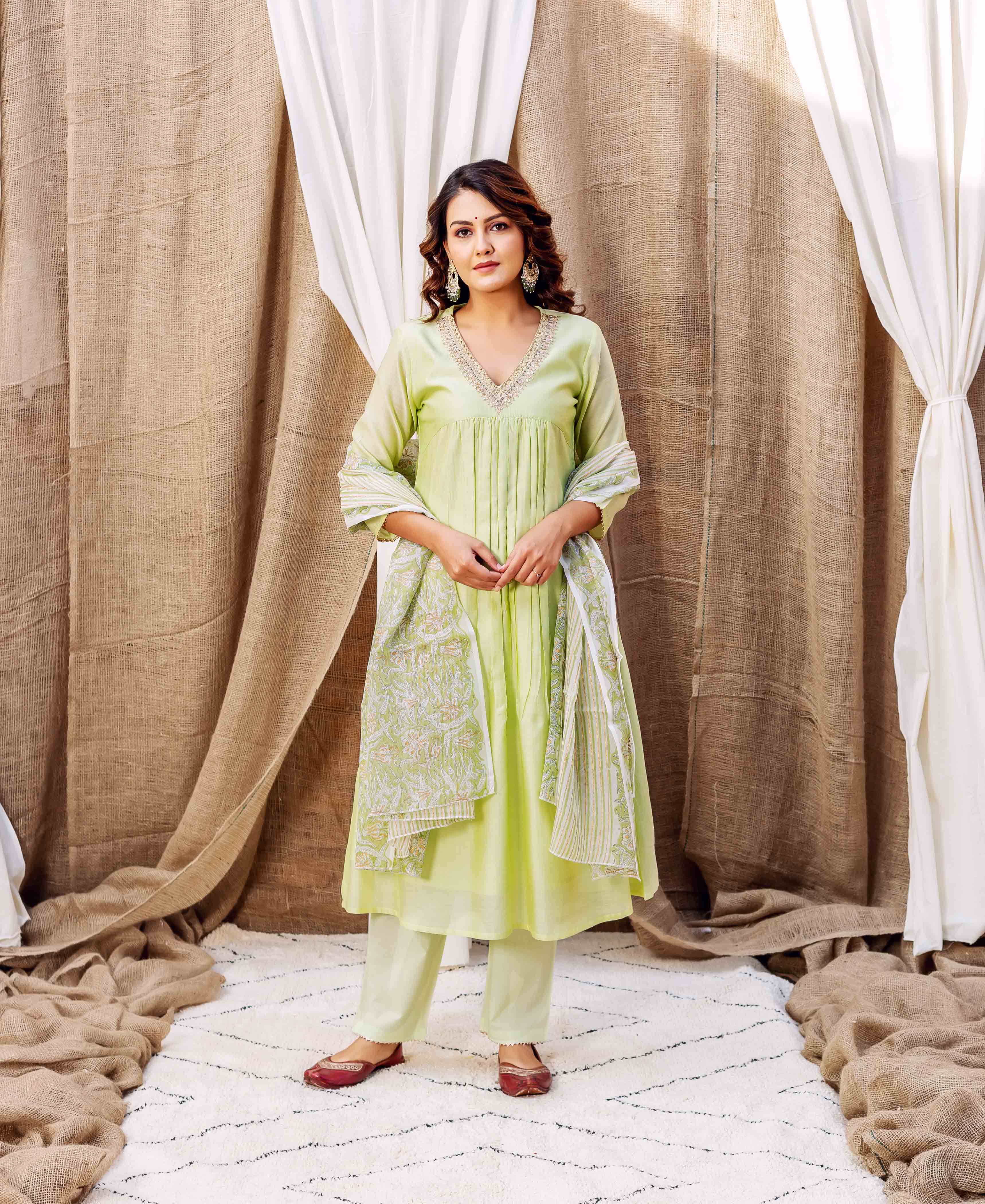 A model wearing a light green kurta with white embroidery and a matching dupatta.