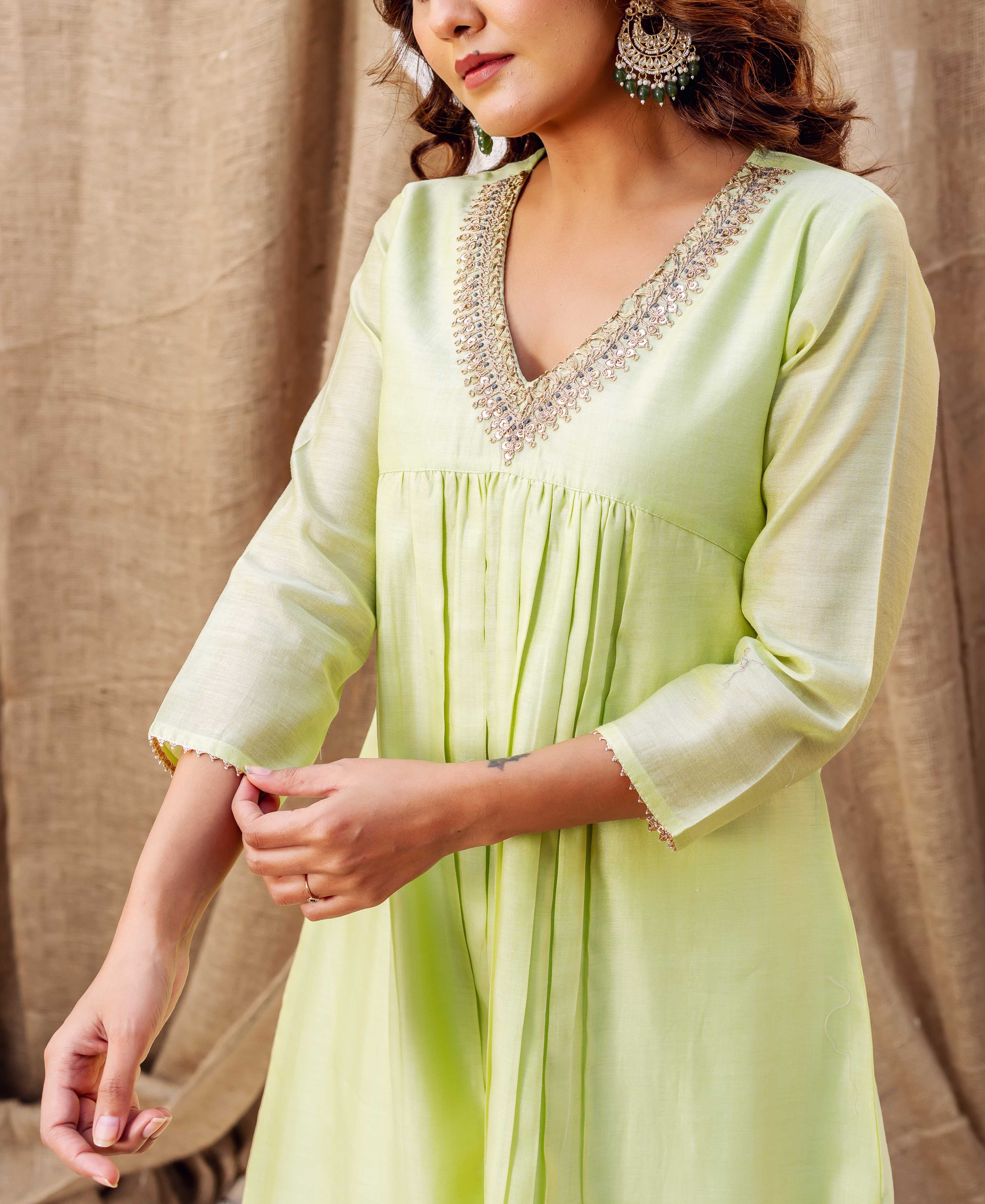 Front view light green kurta on model with detailed embroidered V-neck and gathered front.