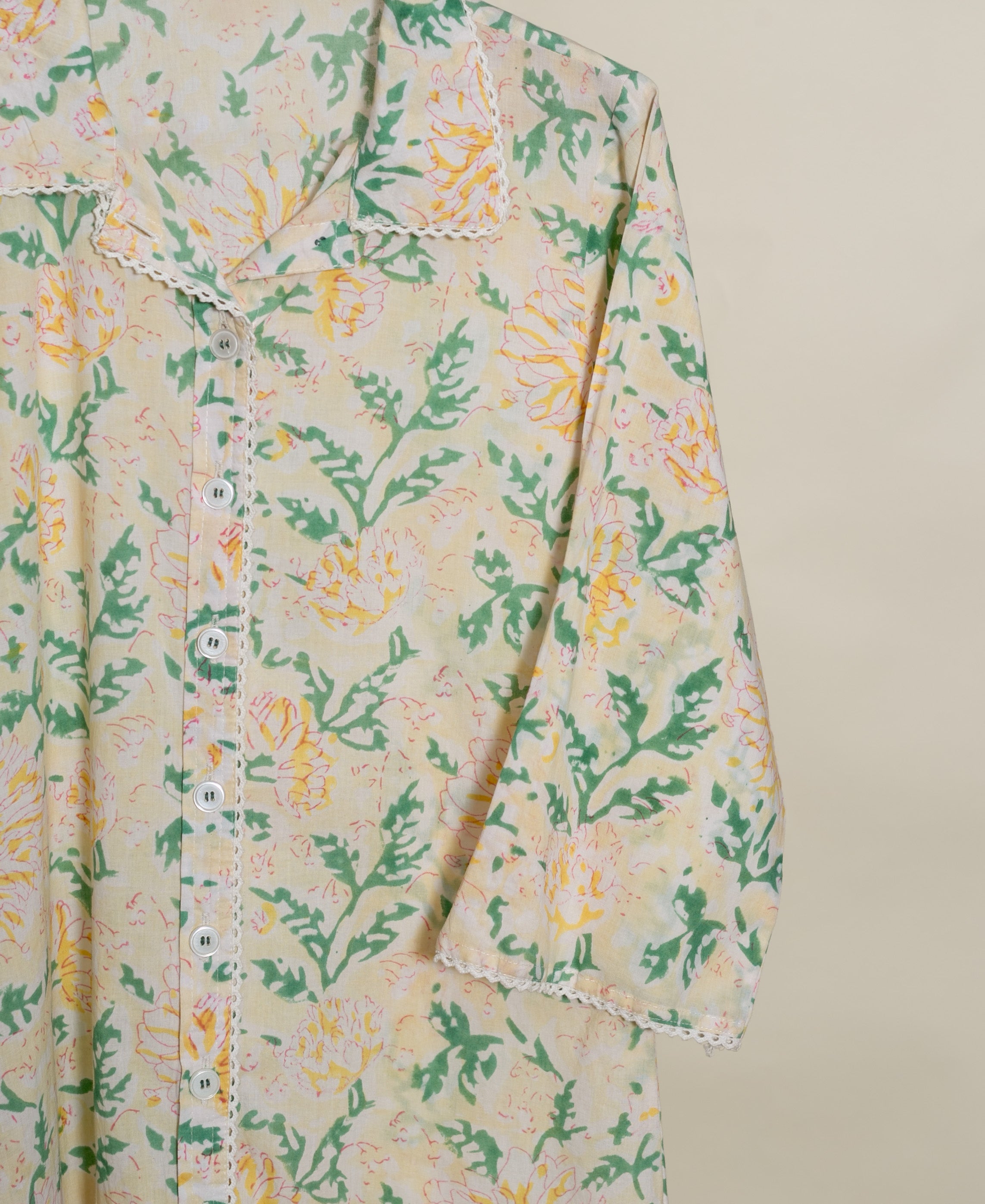 A close-up of a hand-block-printed, ivory cotton co-ord set with a floral pattern.