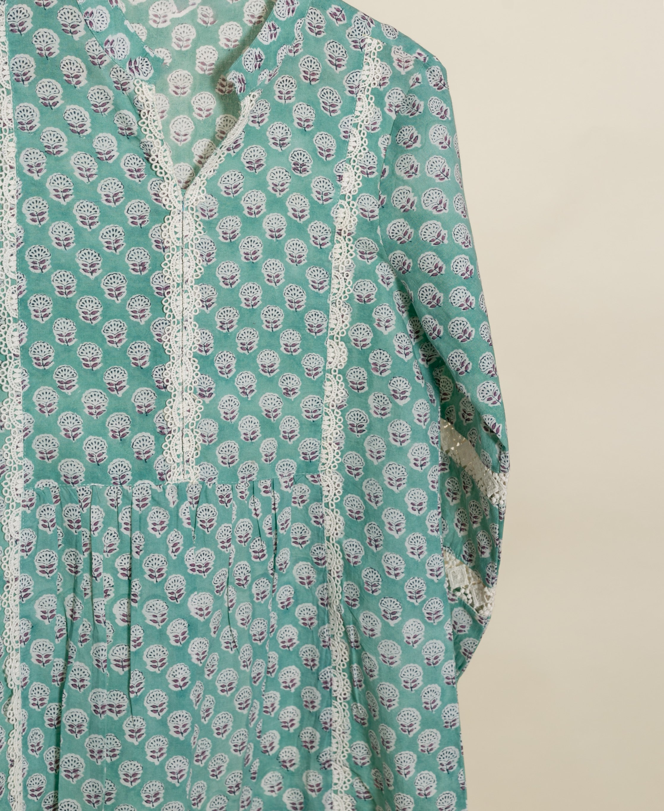 Teal handblock-printed cotton top with white lace trim and small white, purple leaf pattern.