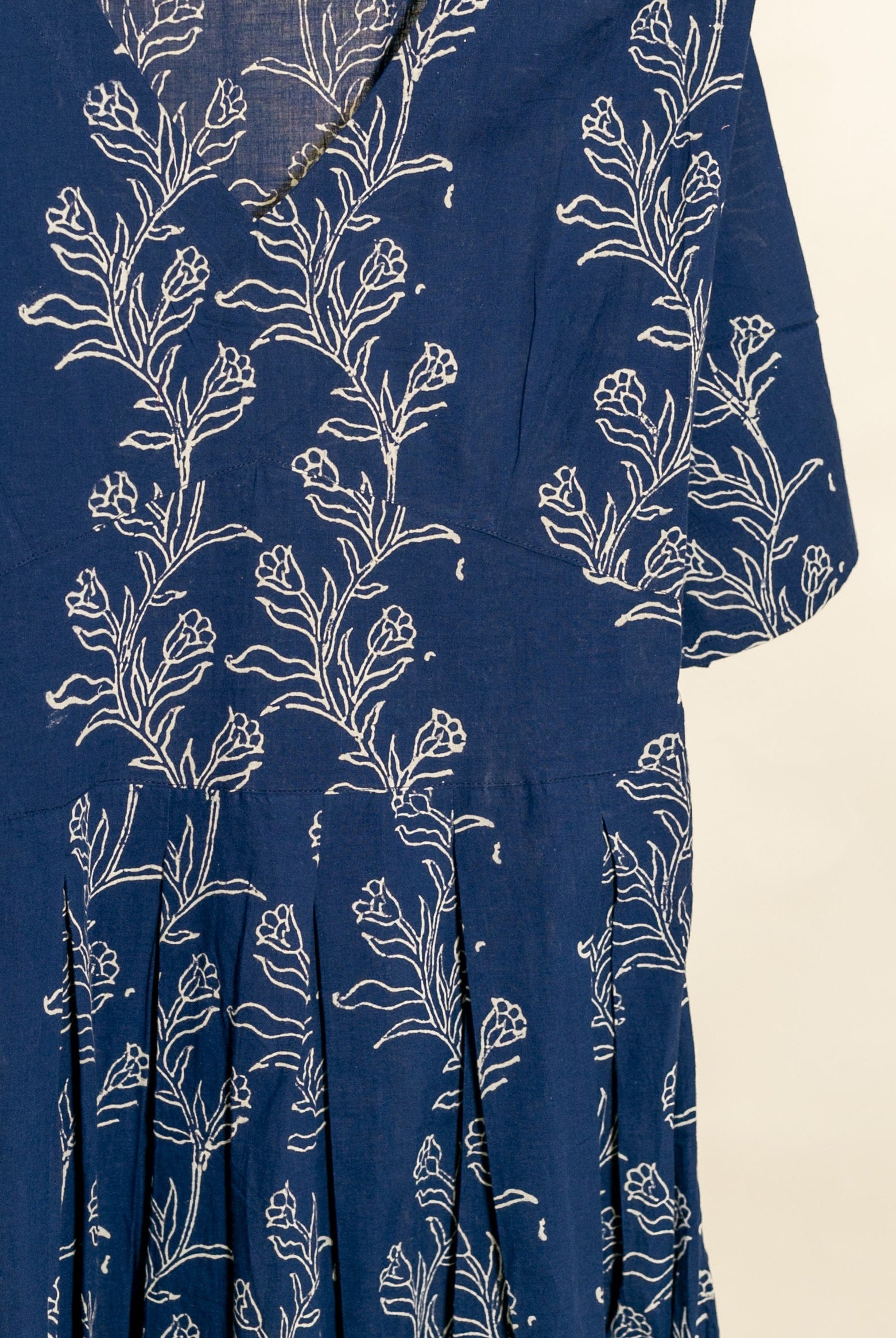 Indigo blue cotton fit-and-flare dress, white botanical handblock print, shown close-up.
