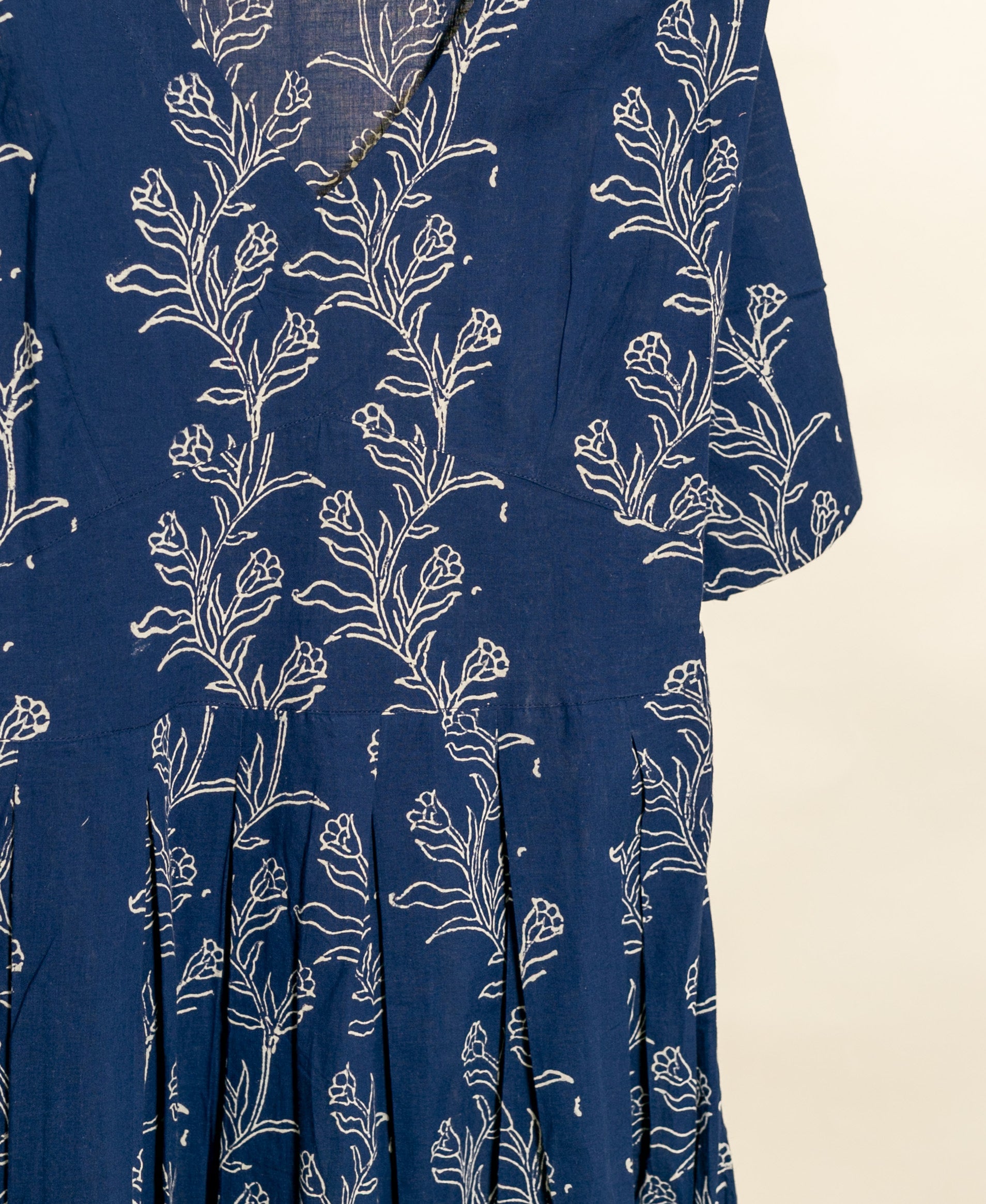 Indigo blue cotton fit-and-flare dress, white botanical handblock print, shown close-up.