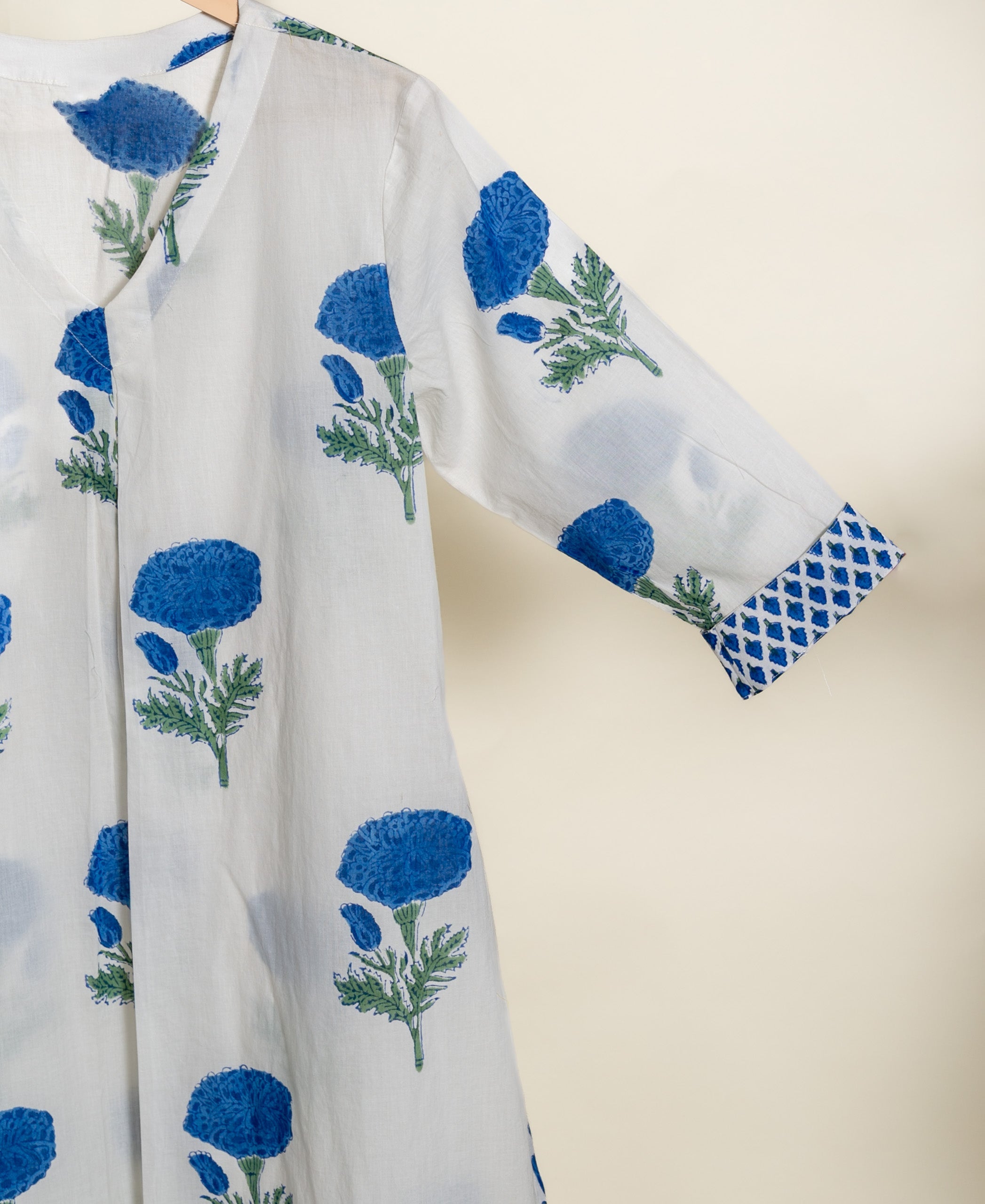 Ivory cotton V-neck kurti with indigo marigold handblock floral print, patterned cuff.
