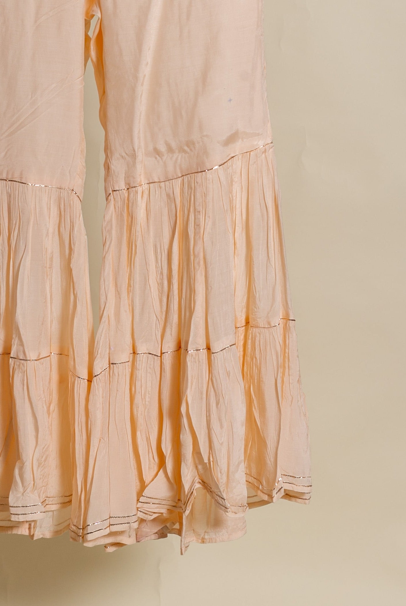 A peach silk chanderi kurta with muslin sharara and chanderi dupatta.