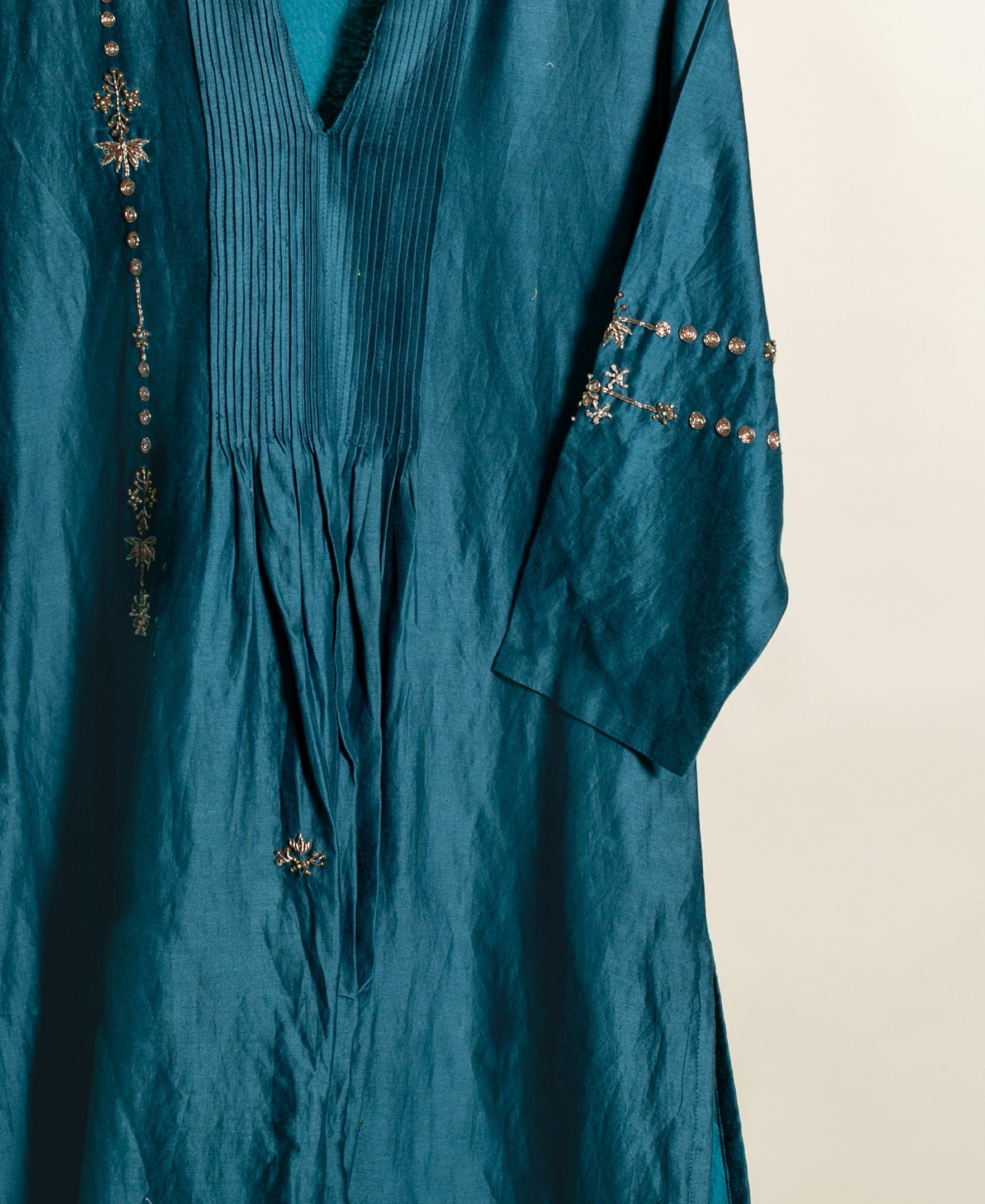 Teal silk kurta with intricate gold embroidery and block print details.