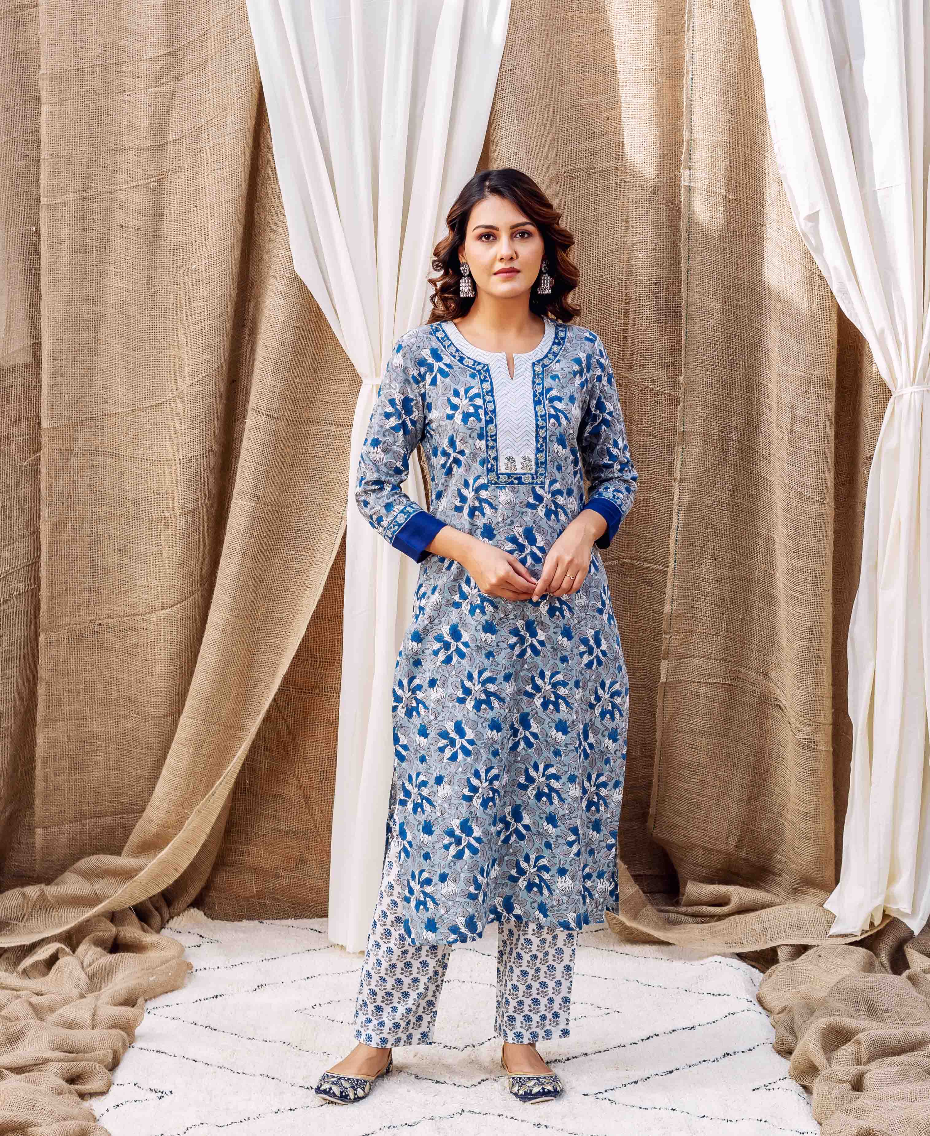 A model wearing a grey and blue cotton straight kurta with floral print.