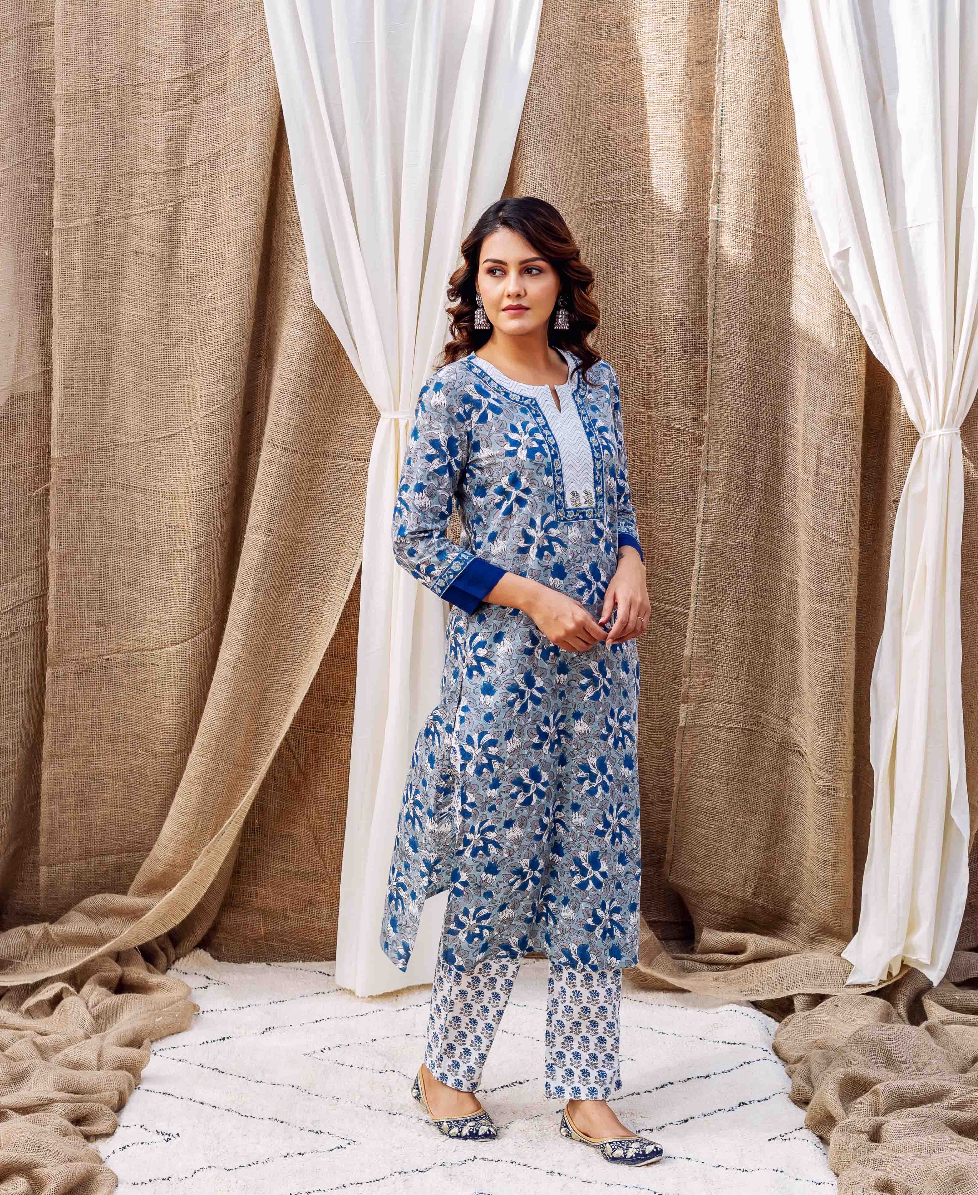 A model wearing a grey and blue cotton straight kurta with floral print.