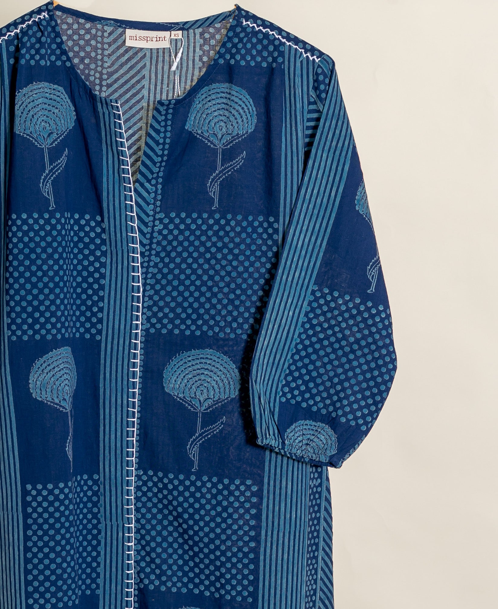 Missprint indigo handblock cotton dress with floral, polka dot, and striped patterns, on hanger.