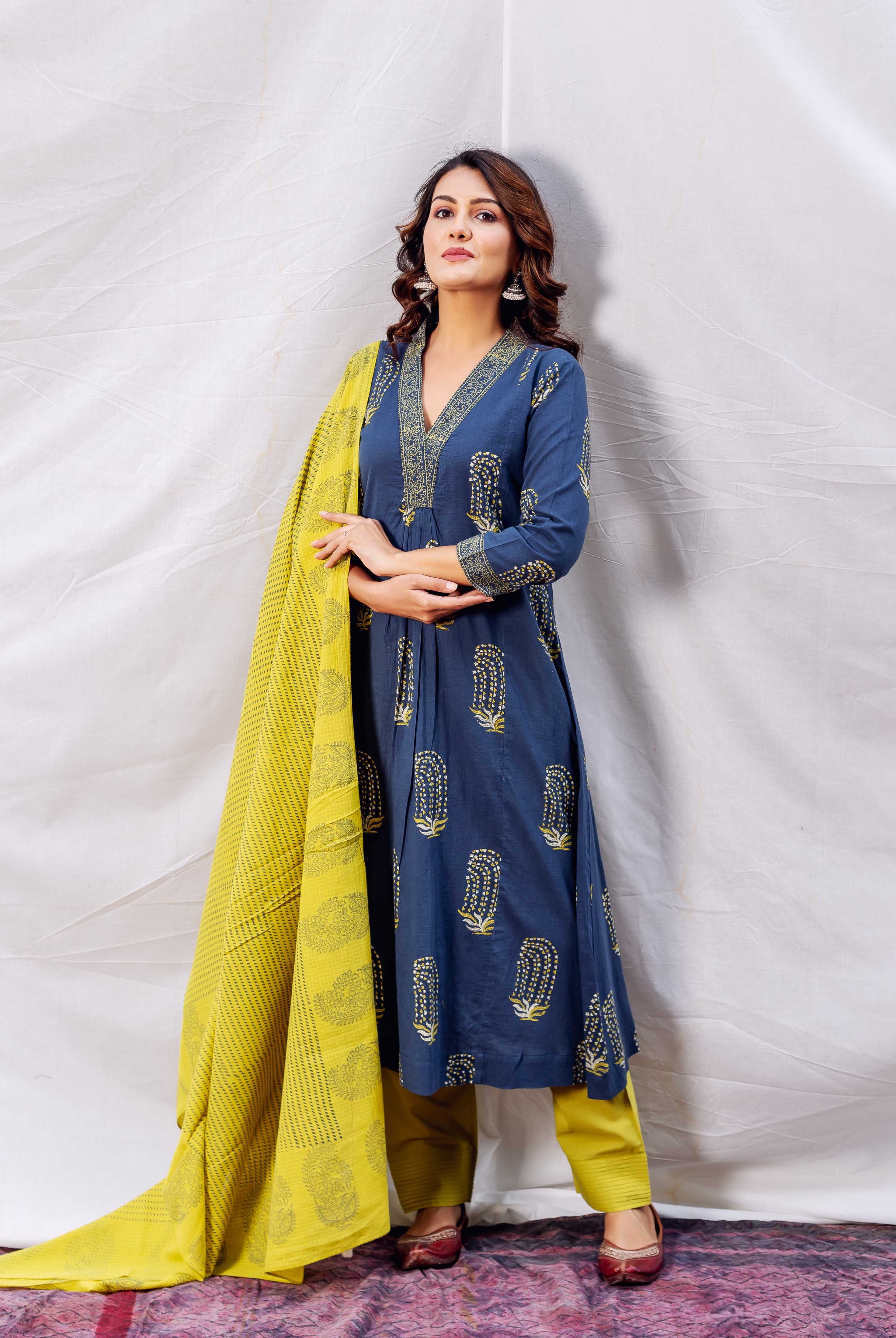 Full look of model in indigo block printed A-line kurta with ochre dupatta and pants.