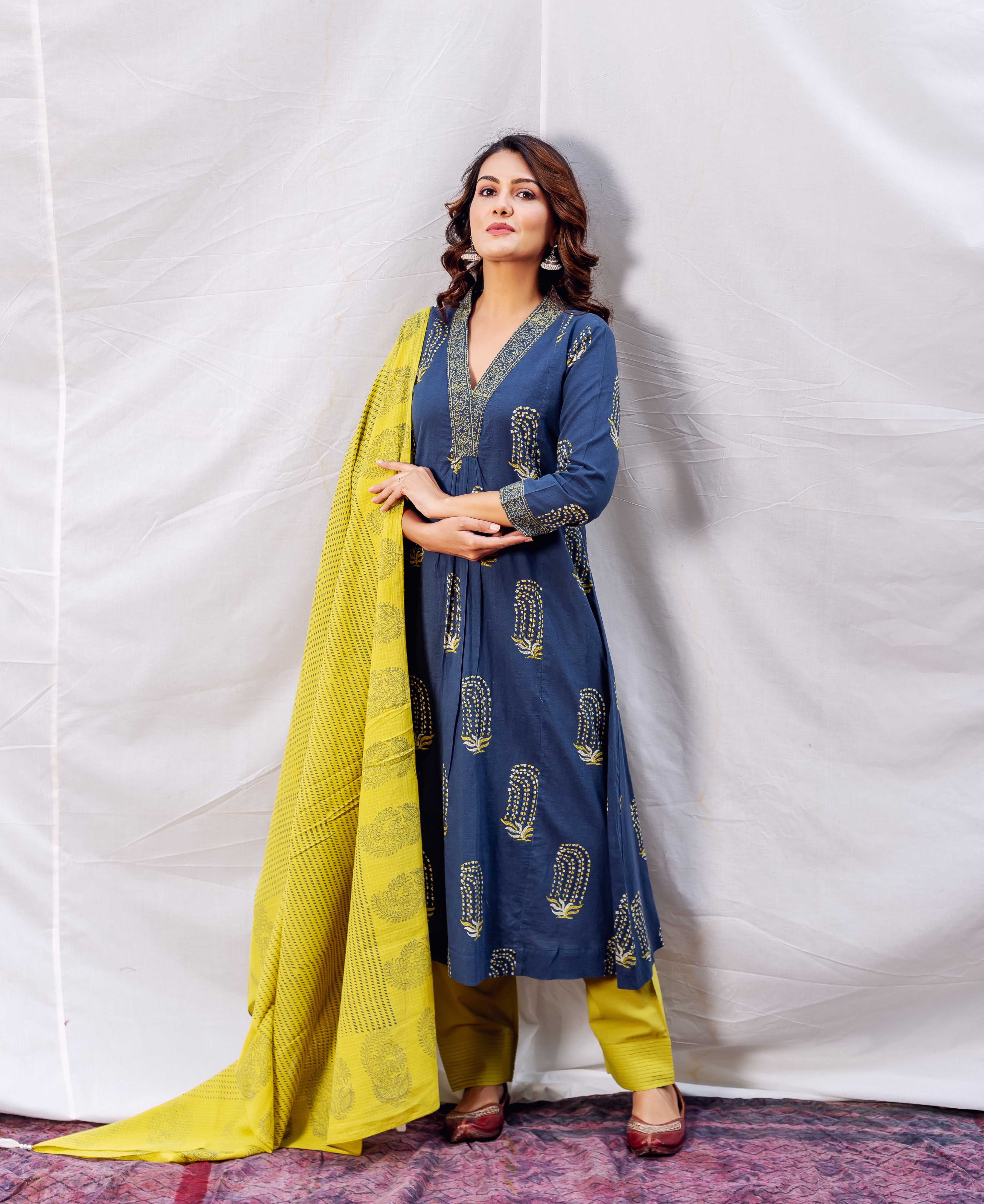 Full look of model in indigo block printed A-line kurta with ochre dupatta and pants.