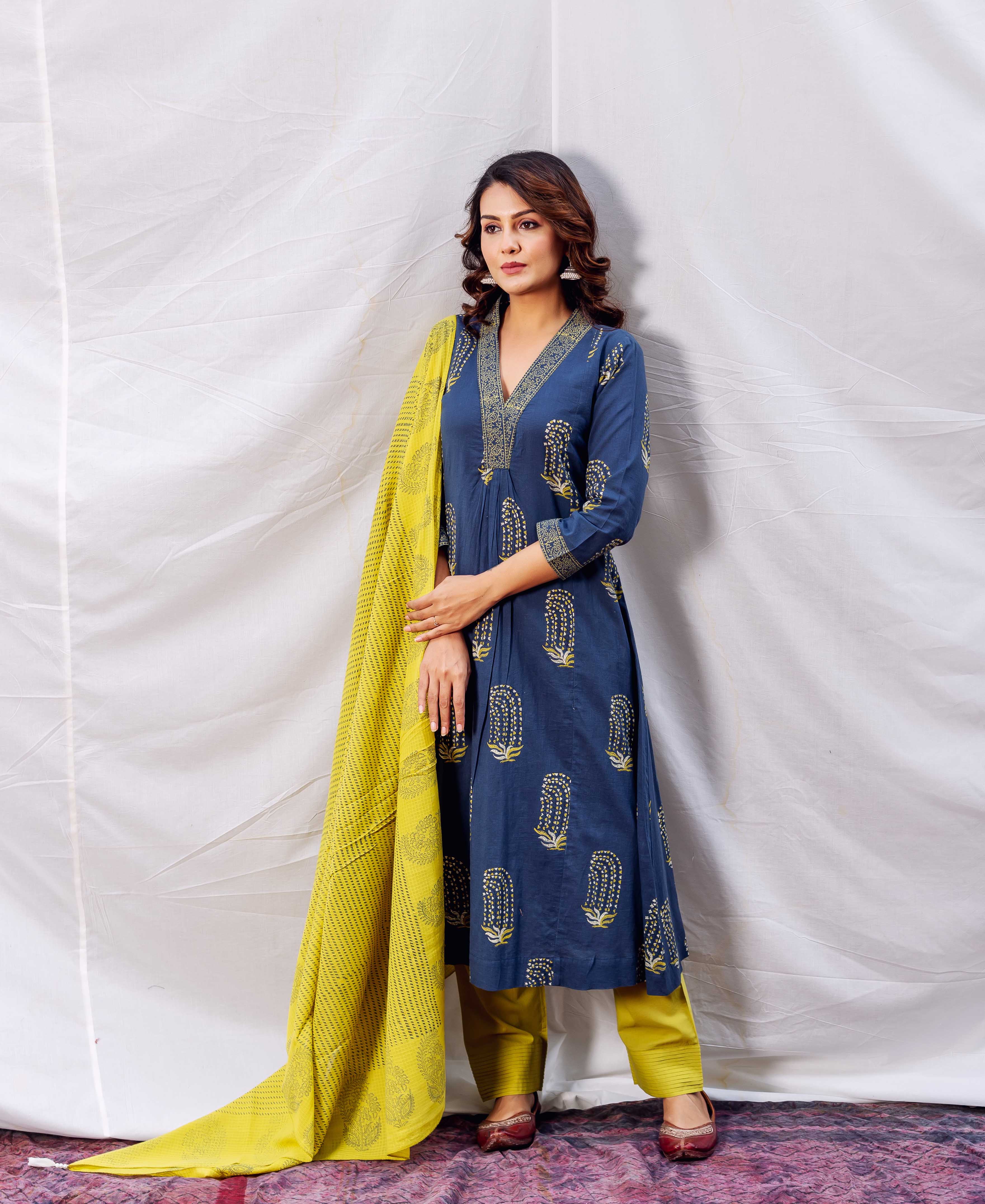 A model wearing an indigo and ochre block-printed A-line kurta with a yellow dupatta.