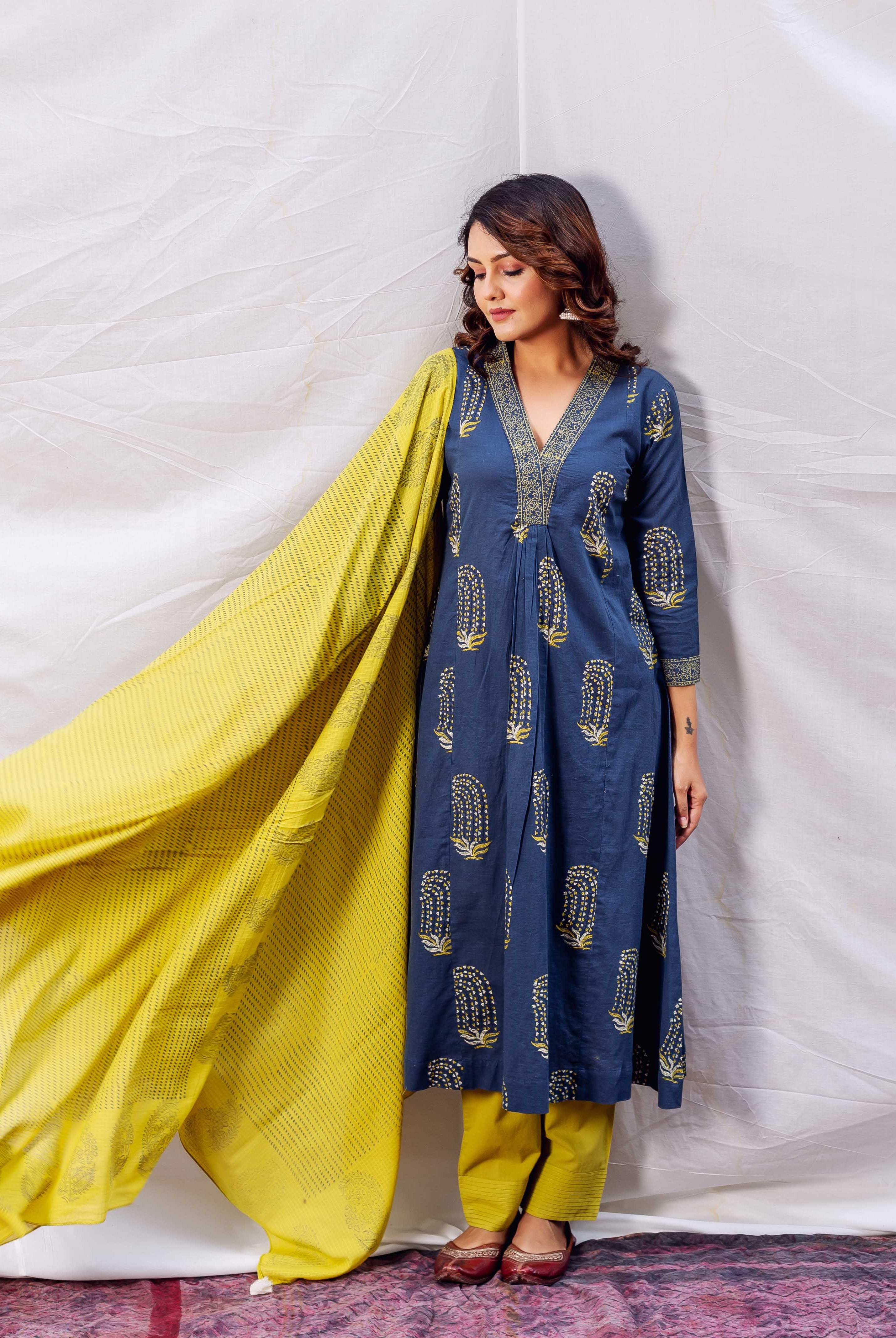Model wearing indigo A-line kurta with ochre print, yellow pants and flowing dupatta.