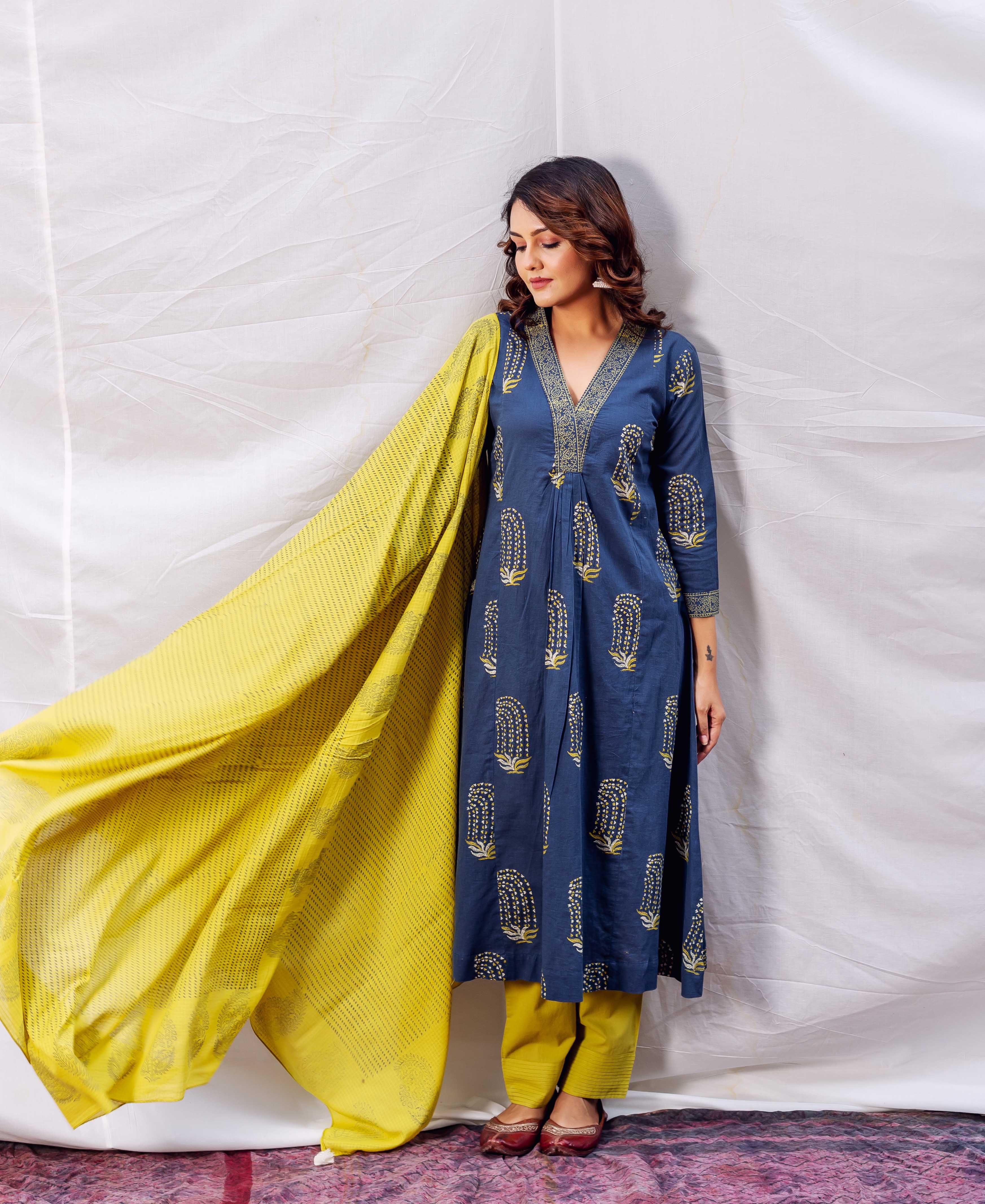 Model wearing indigo A-line kurta with ochre print, yellow pants and flowing dupatta.