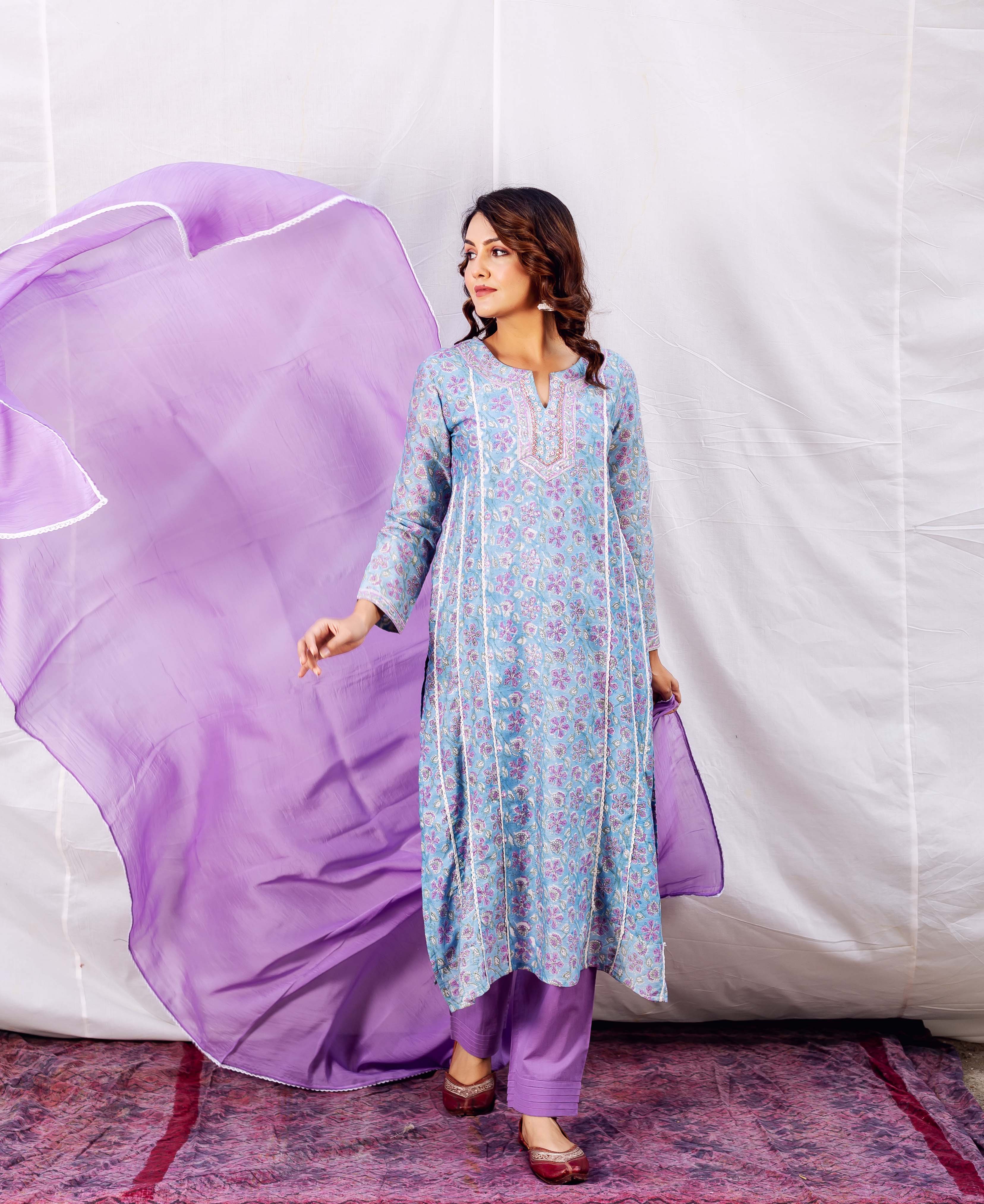 Model in light blue floral hand-block printed kurta, embroidered neckline, purple pants and dupatta.