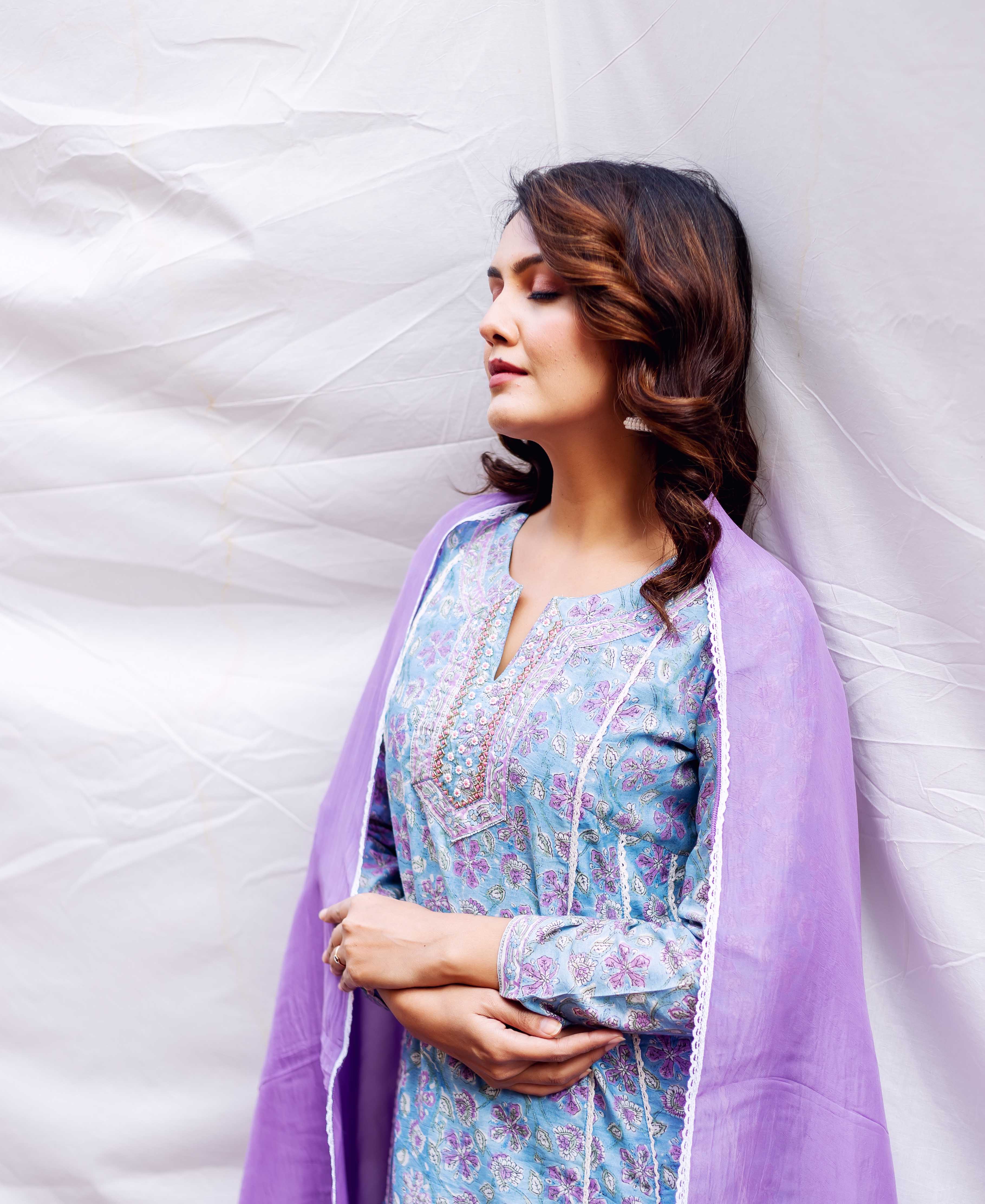 Model wears light blue kurta with purple floral hand-block print, embroidered neckline, and lilac dupatta.