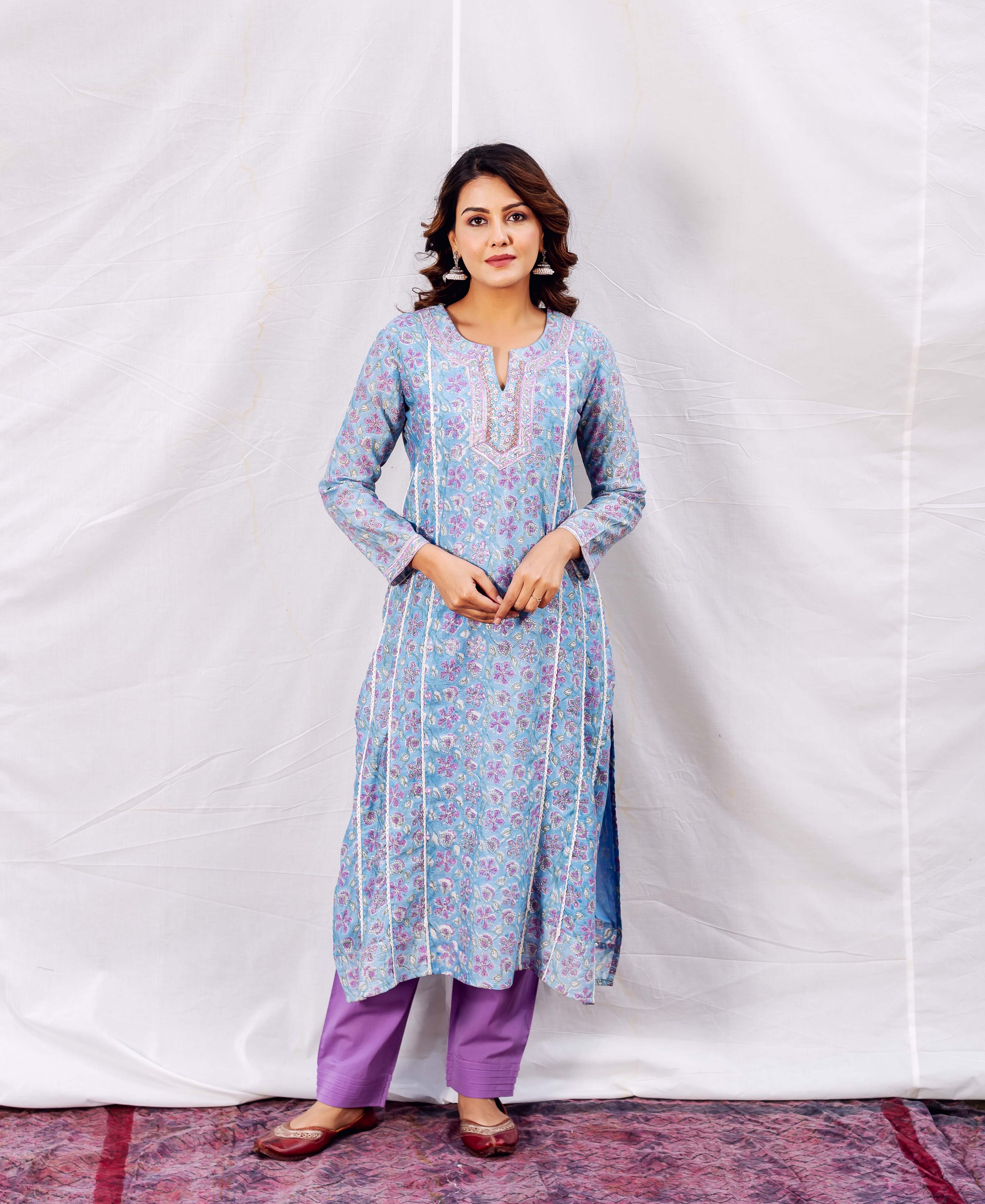 Model in a light blue floral printed kurta with white embroidery and purple pants.