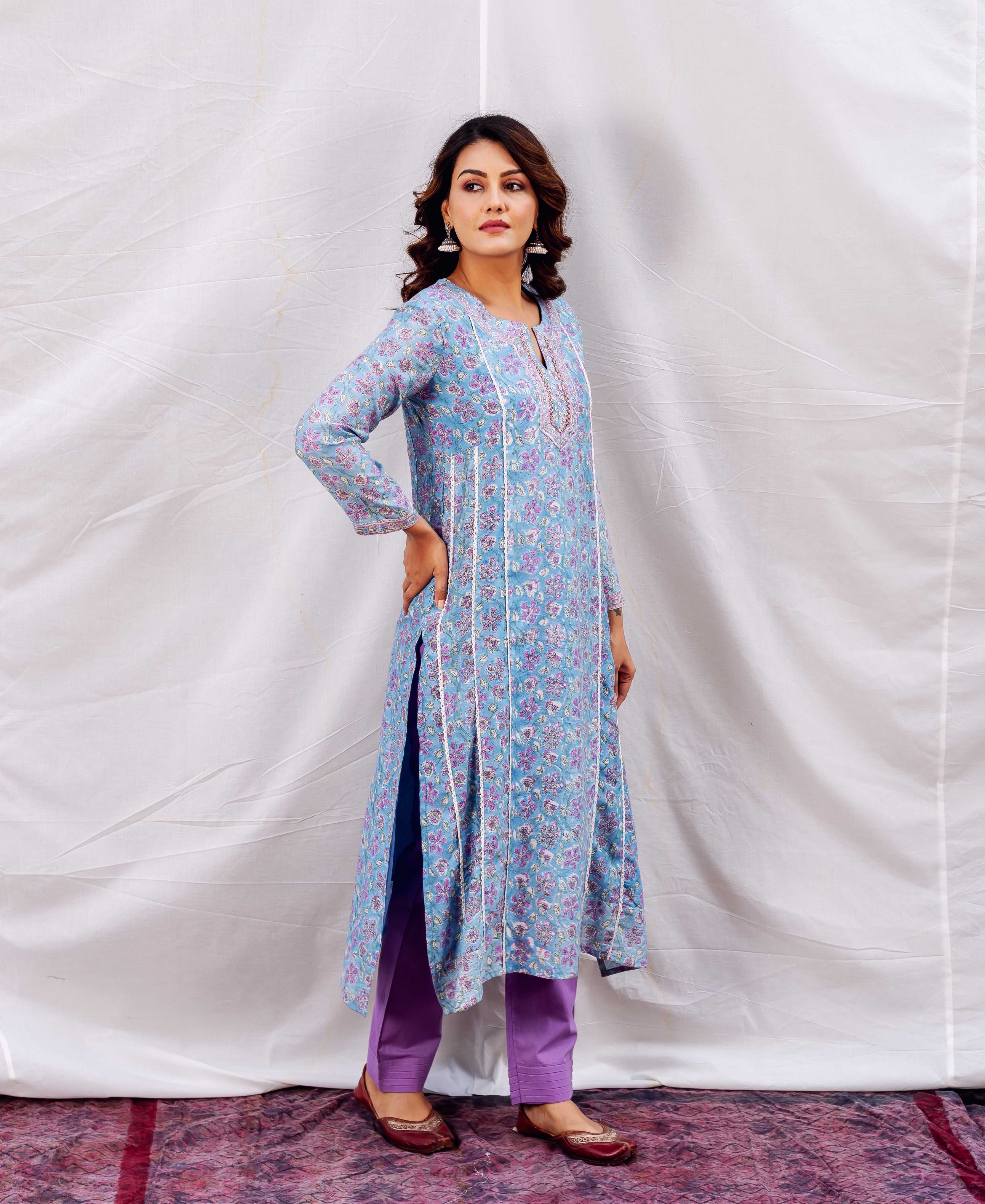 Full-body model wears light blue floral kurta with embroidered neckline, white trim, and purple pants.