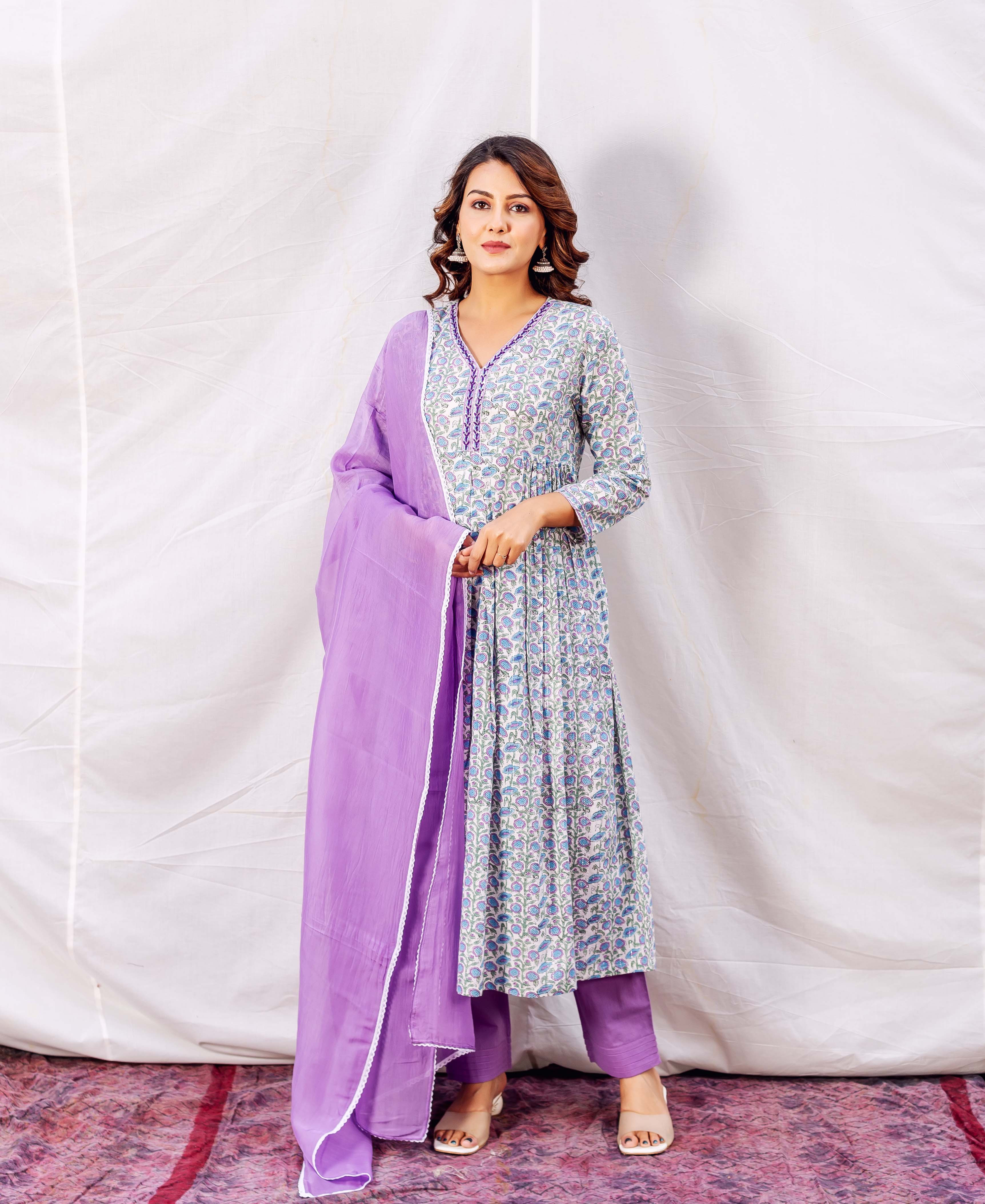 Model in purple-trimmed floral hand-block printed A-line kurta set with purple pants and dupatta.