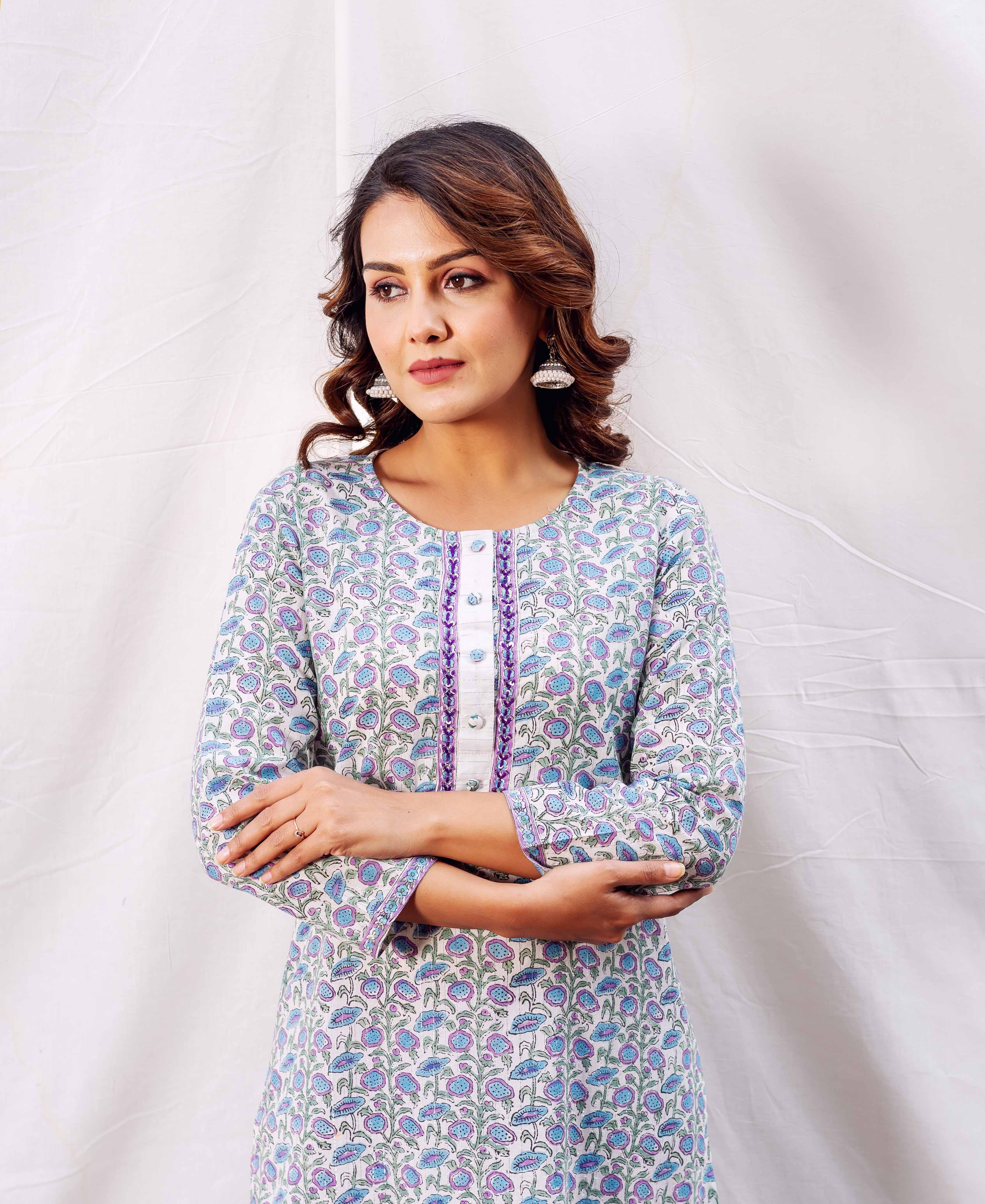 Model wearing off-white straight kurta with blue, purple floral hand-block print and purple trim.