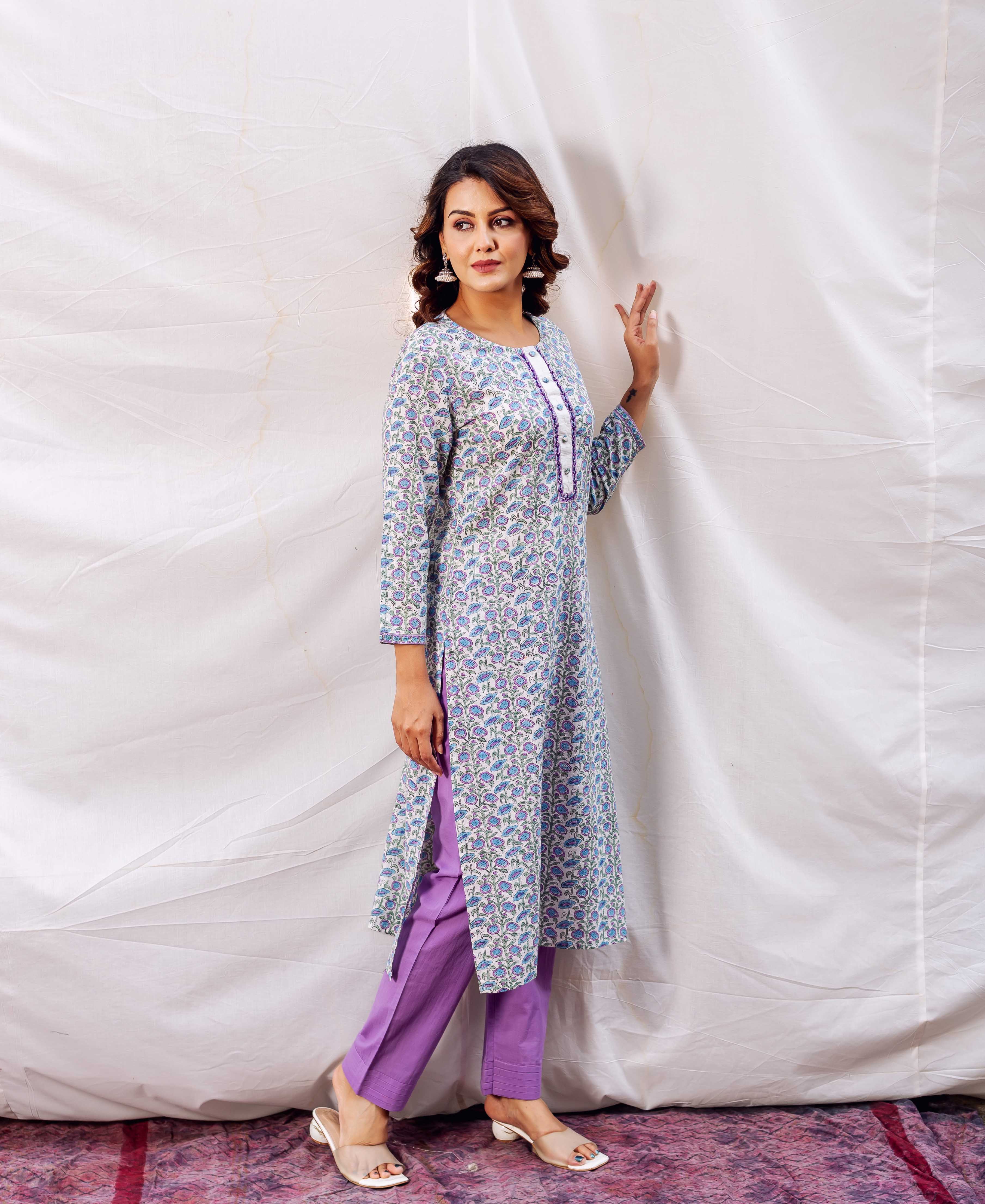 Full shot of model wearing light blue and purple floral block-printed kurta with purple pants.