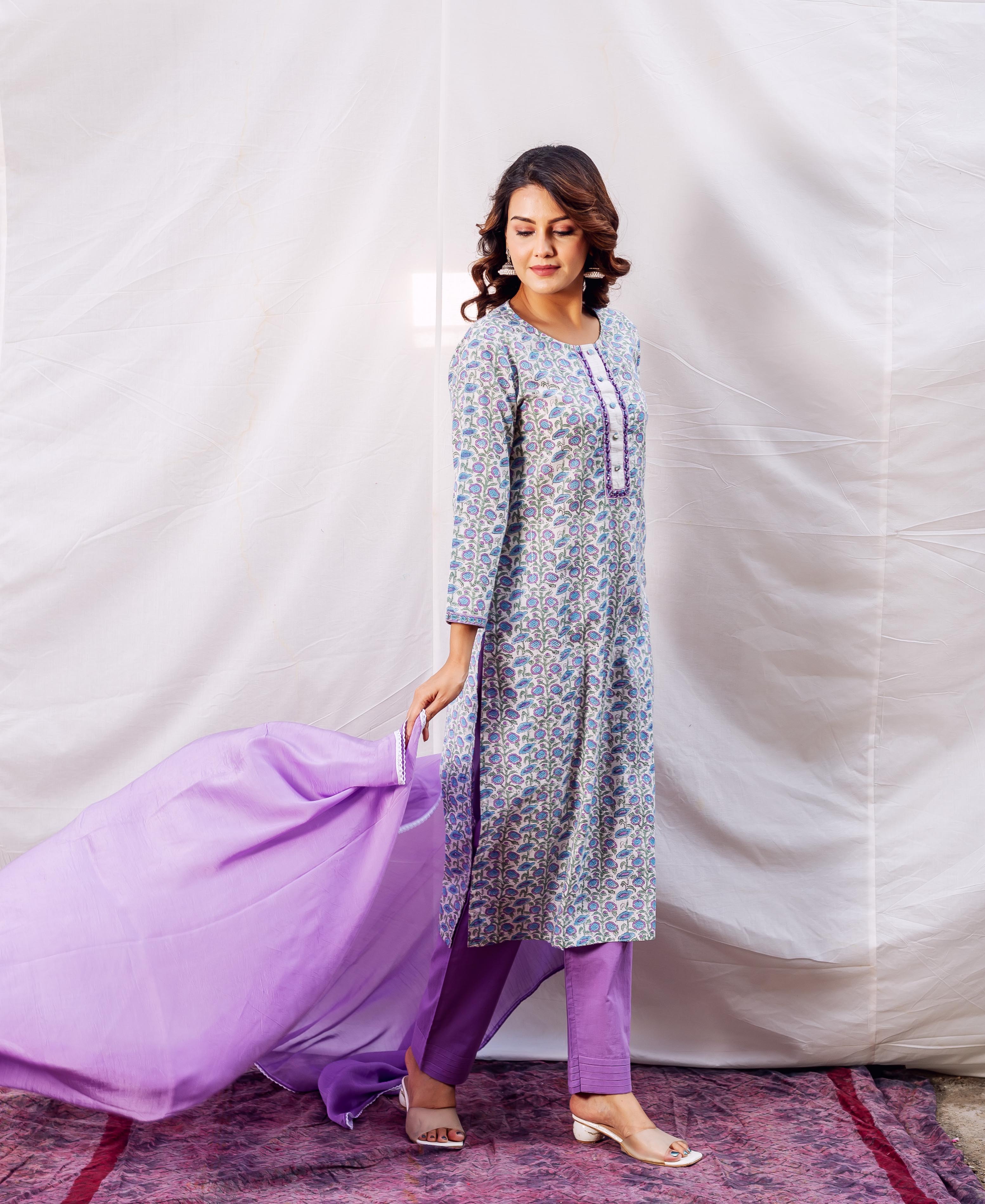 Model wears a light blue floral printed straight kurta, purple pants, and matching dupatta.