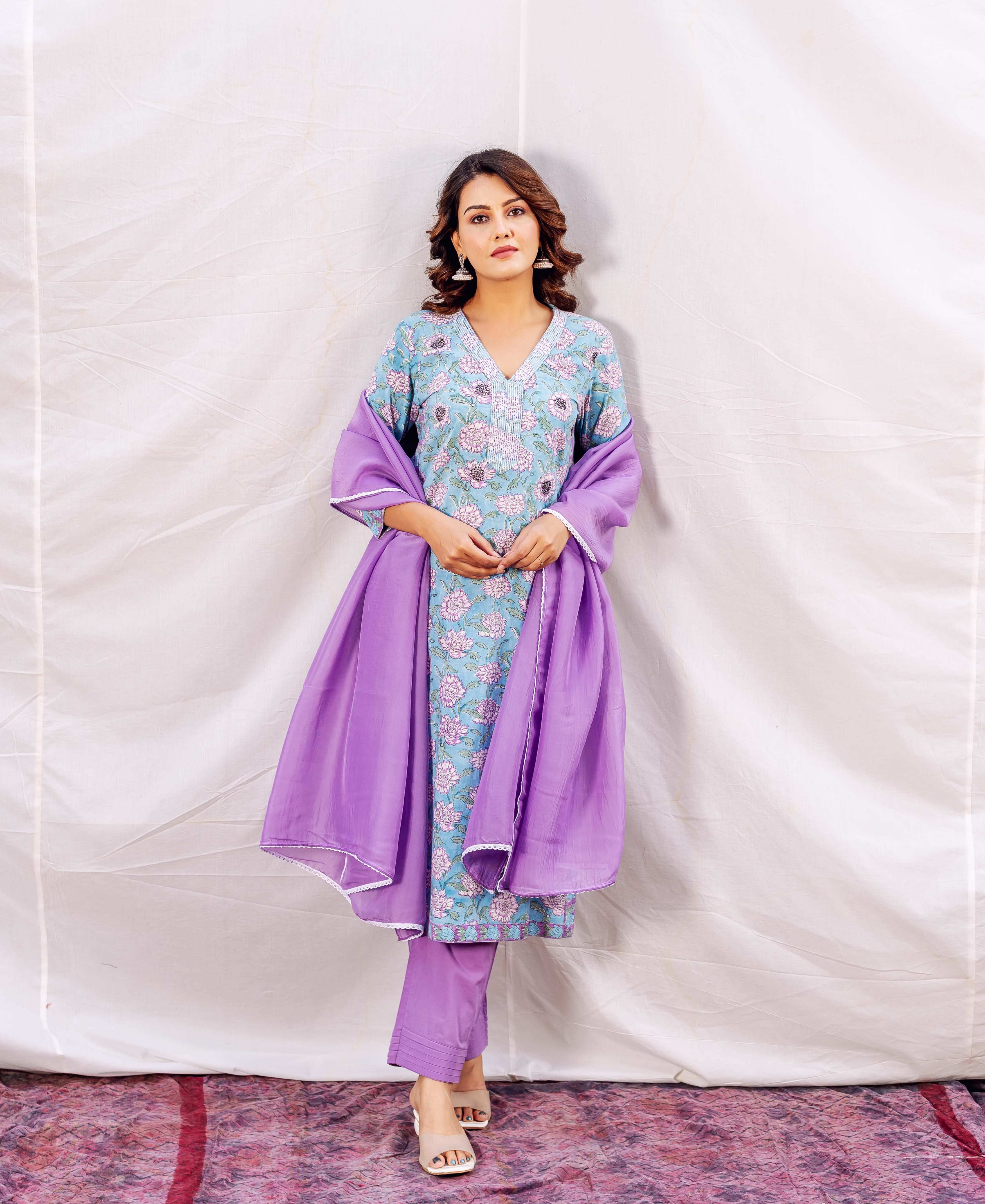 Full-length model wears a light blue floral hand-block printed kurta with purple pants and dupatta.