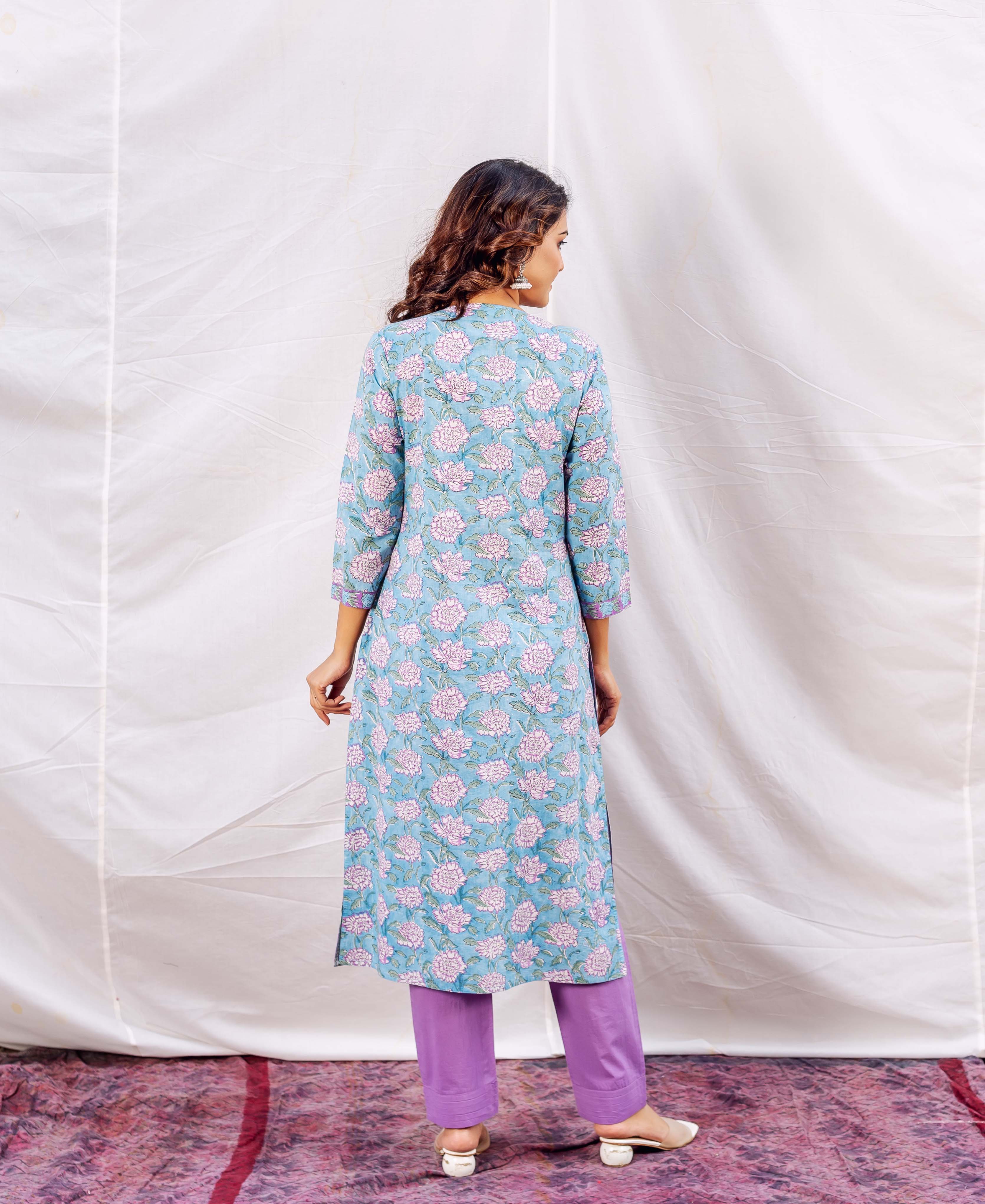 Back view of a model in a light blue floral block-printed kurta and purple pants.
