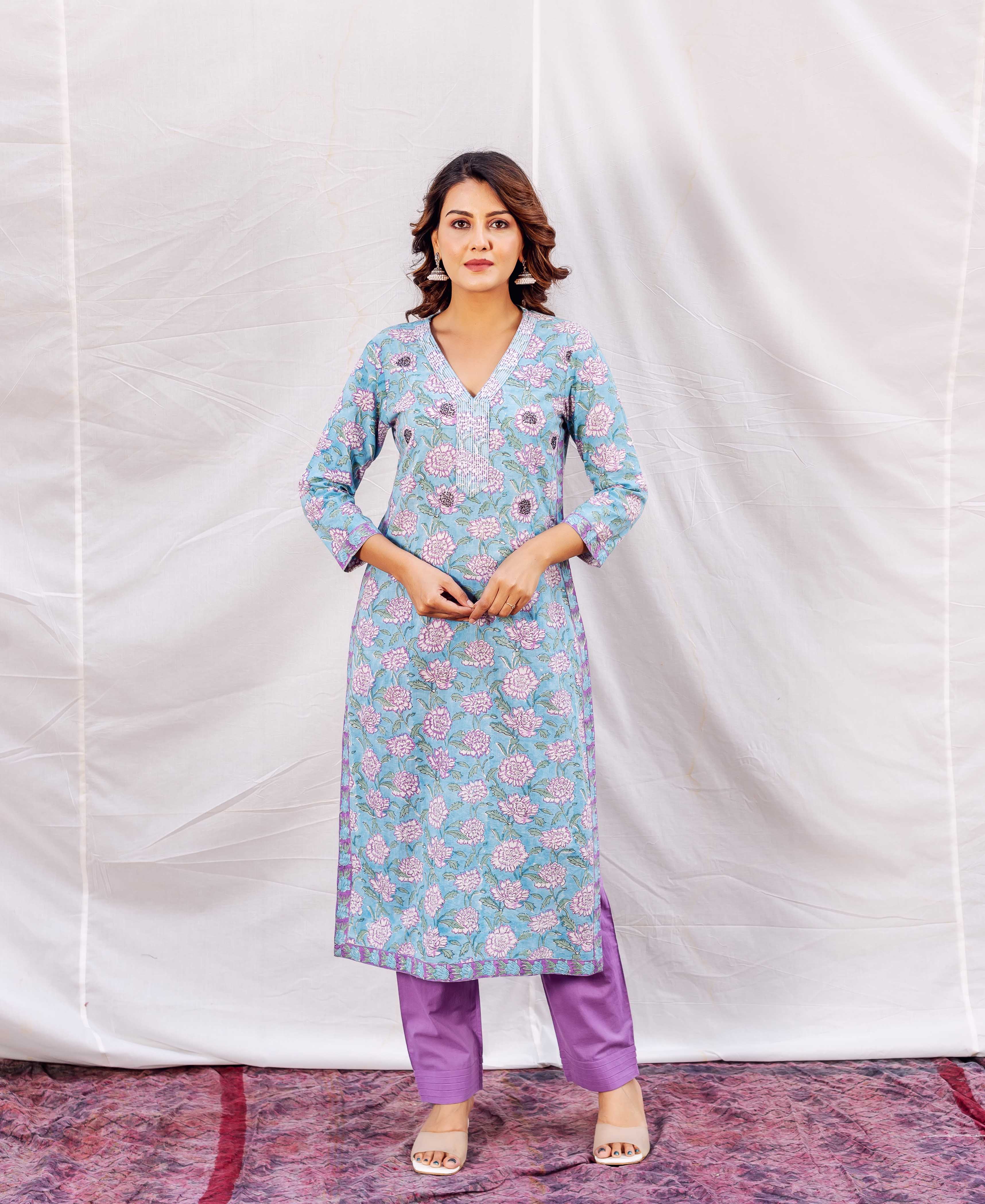Full-length model in light blue V-neck floral hand-block printed kurta and purple pants.