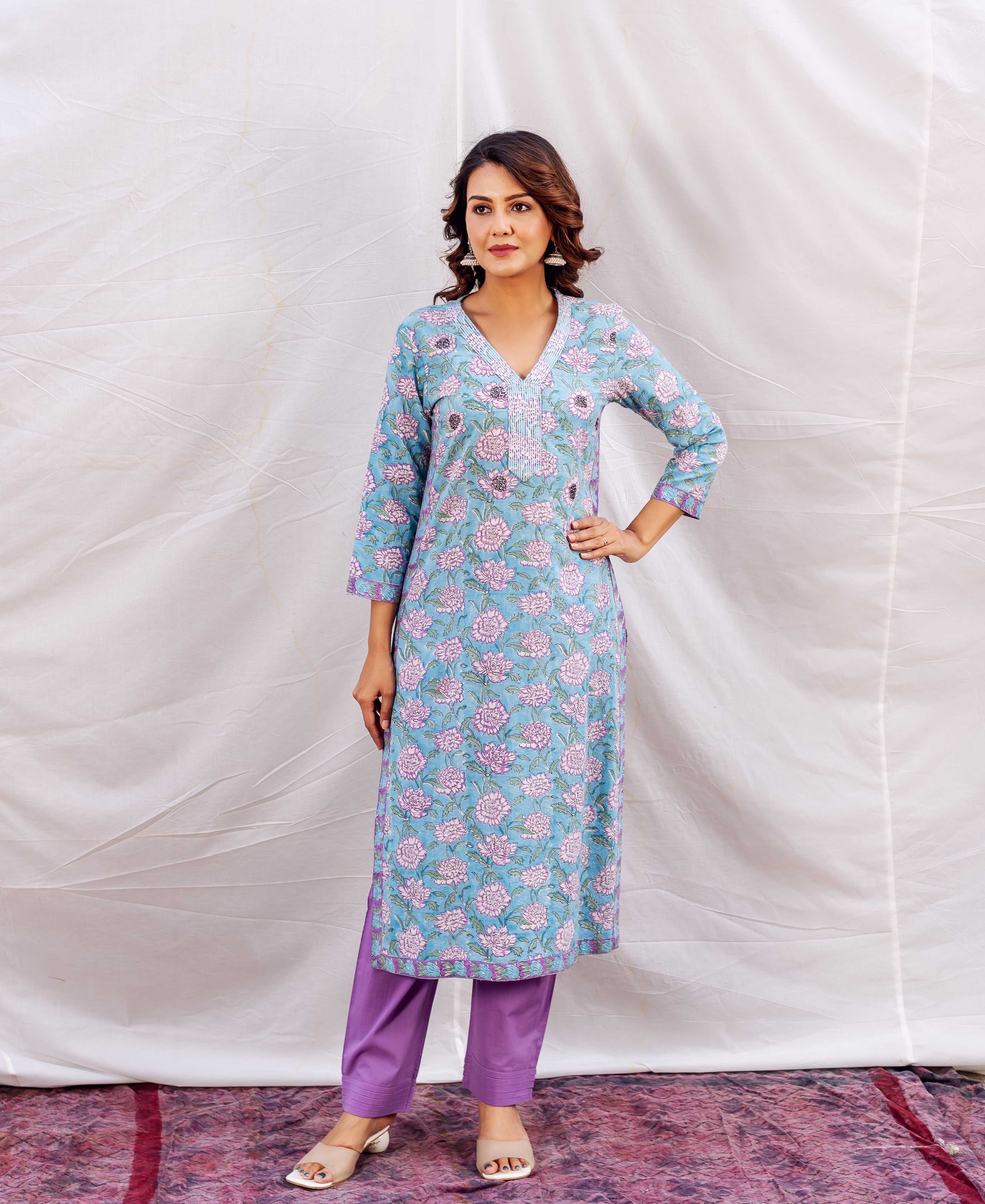 Model in a light blue hand-block print straight kurta with pink florals and embroidered V-neck.