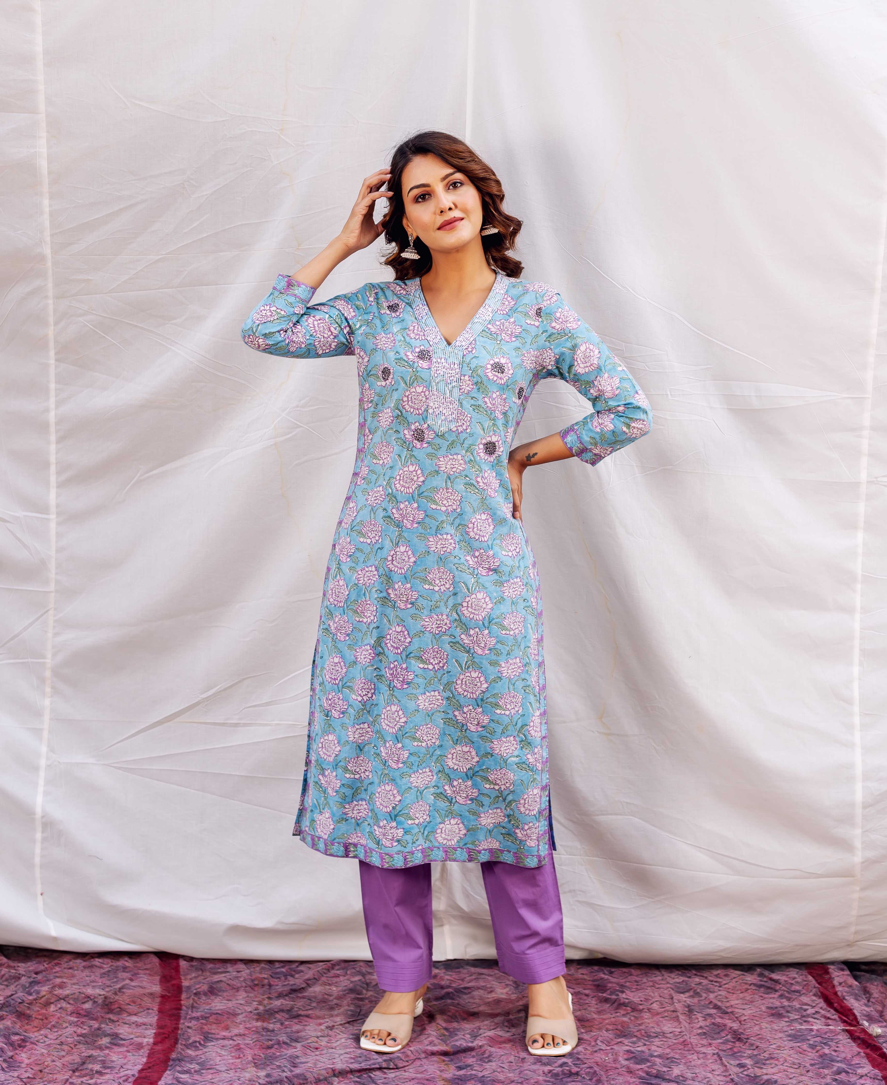 Model in a blue floral hand-block-printed straight embroidered kurta and purple pants.