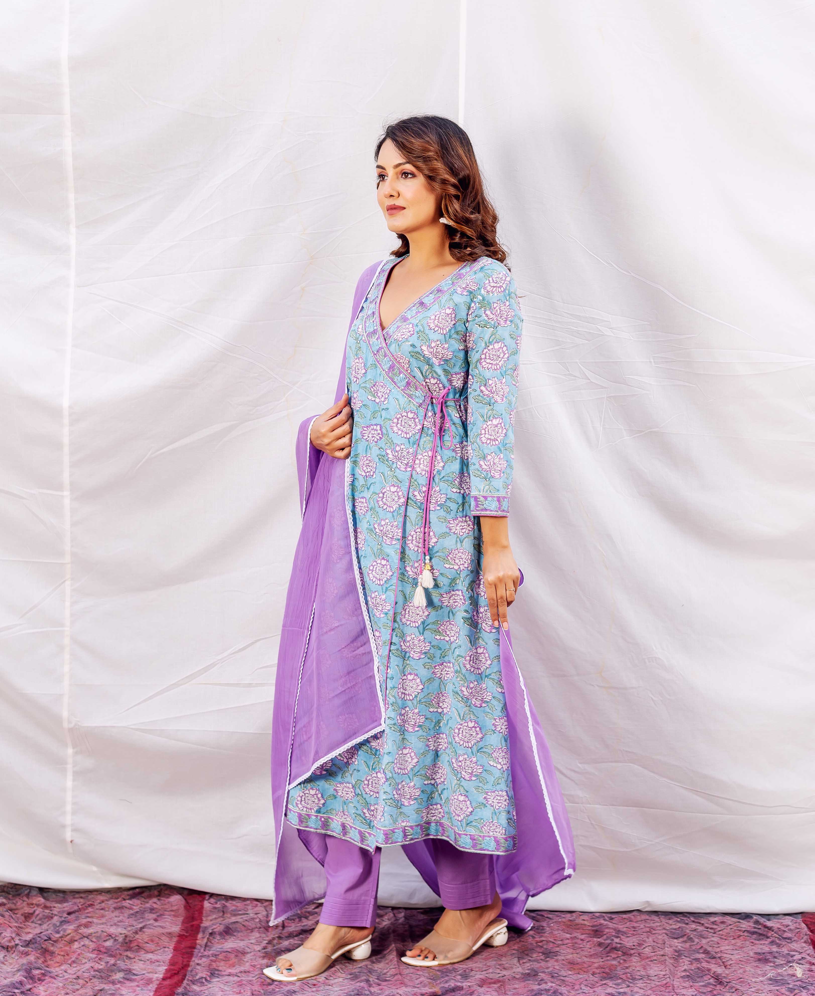 Model in a light blue floral angrakha kurta with purple dupatta and matching pants.