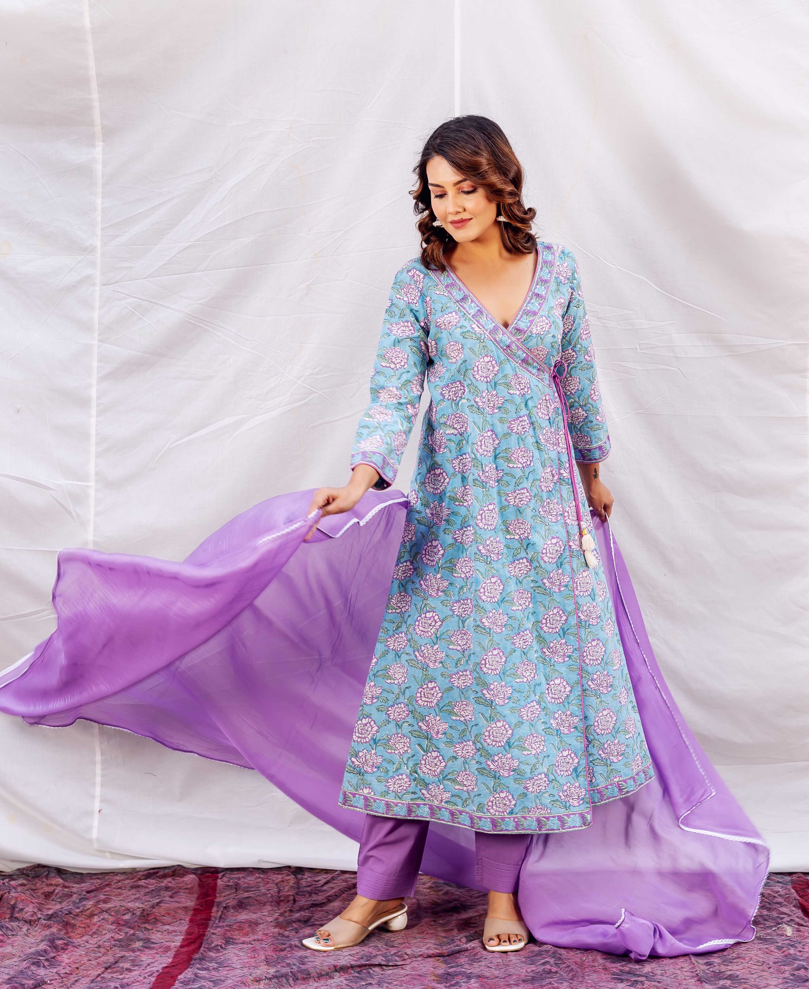 Woman in a sky-blue floral hand-block printed Angrakha kurta set with a purple dupatta.