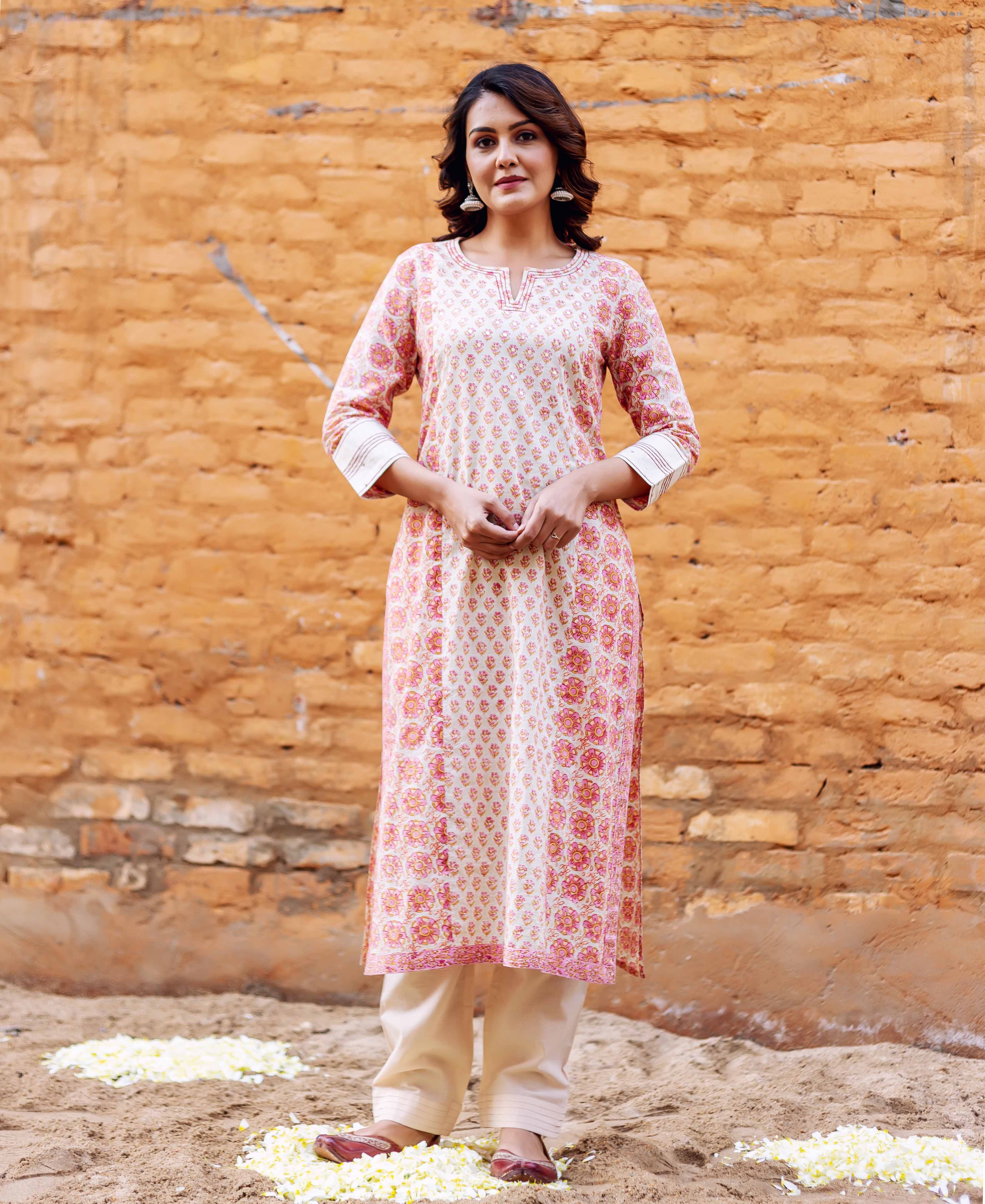 Model in full-length cream and pink block printed straight kurta with floral design.