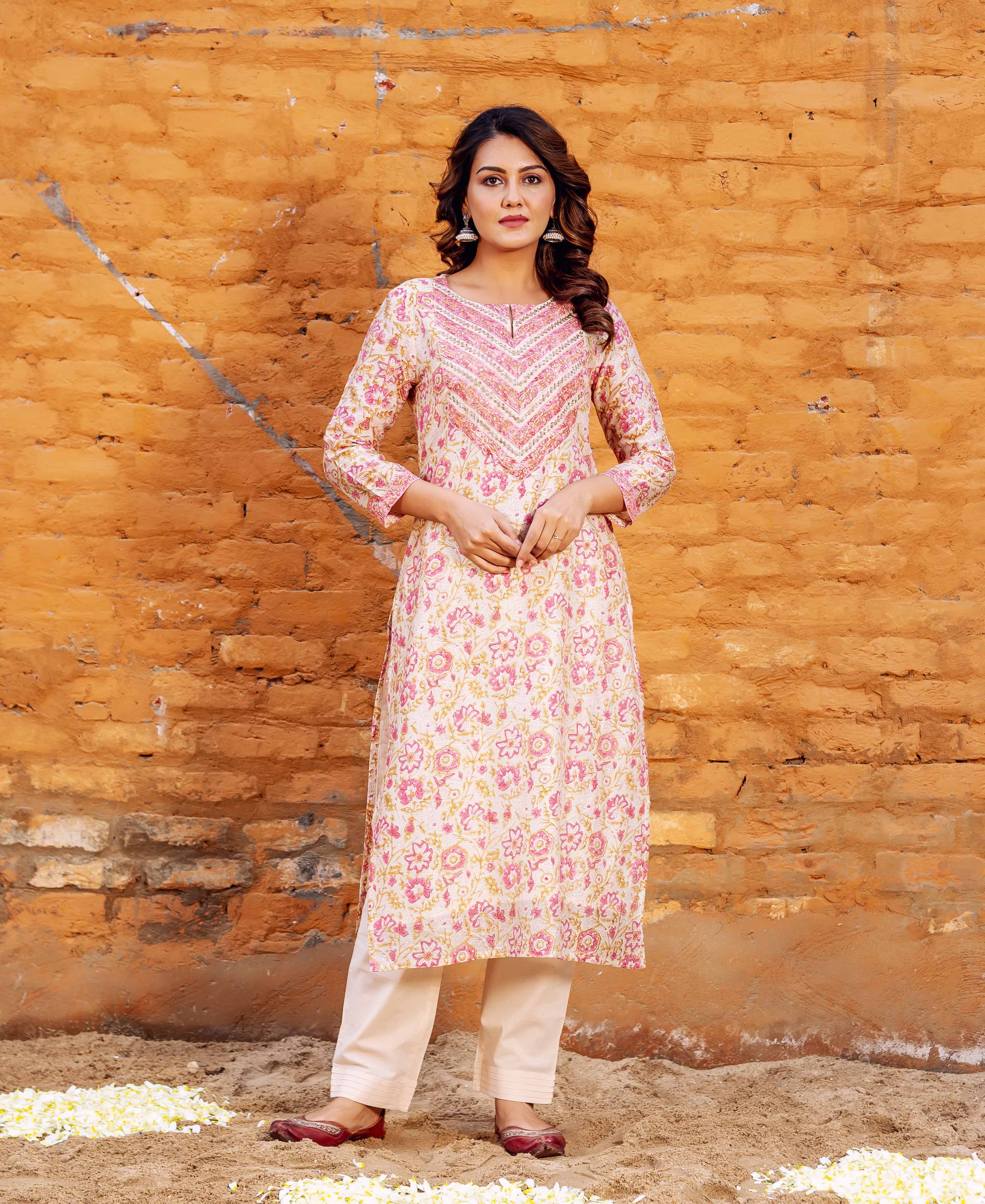 Front view model in off-white pink floral block printed straight kurta with cream pants.