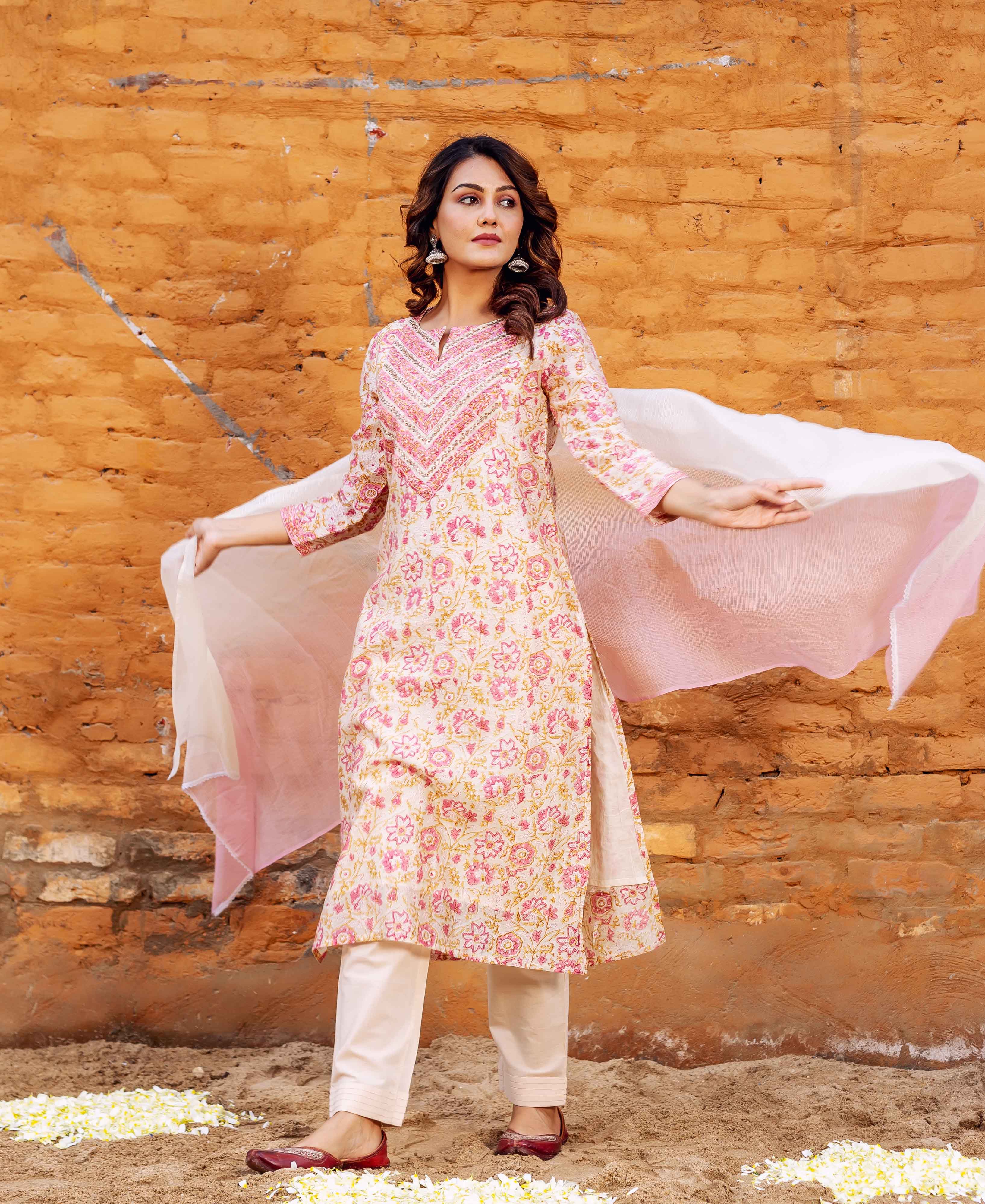 Model in a cream and pink floral block printed kurta set with a sheer dupatta.